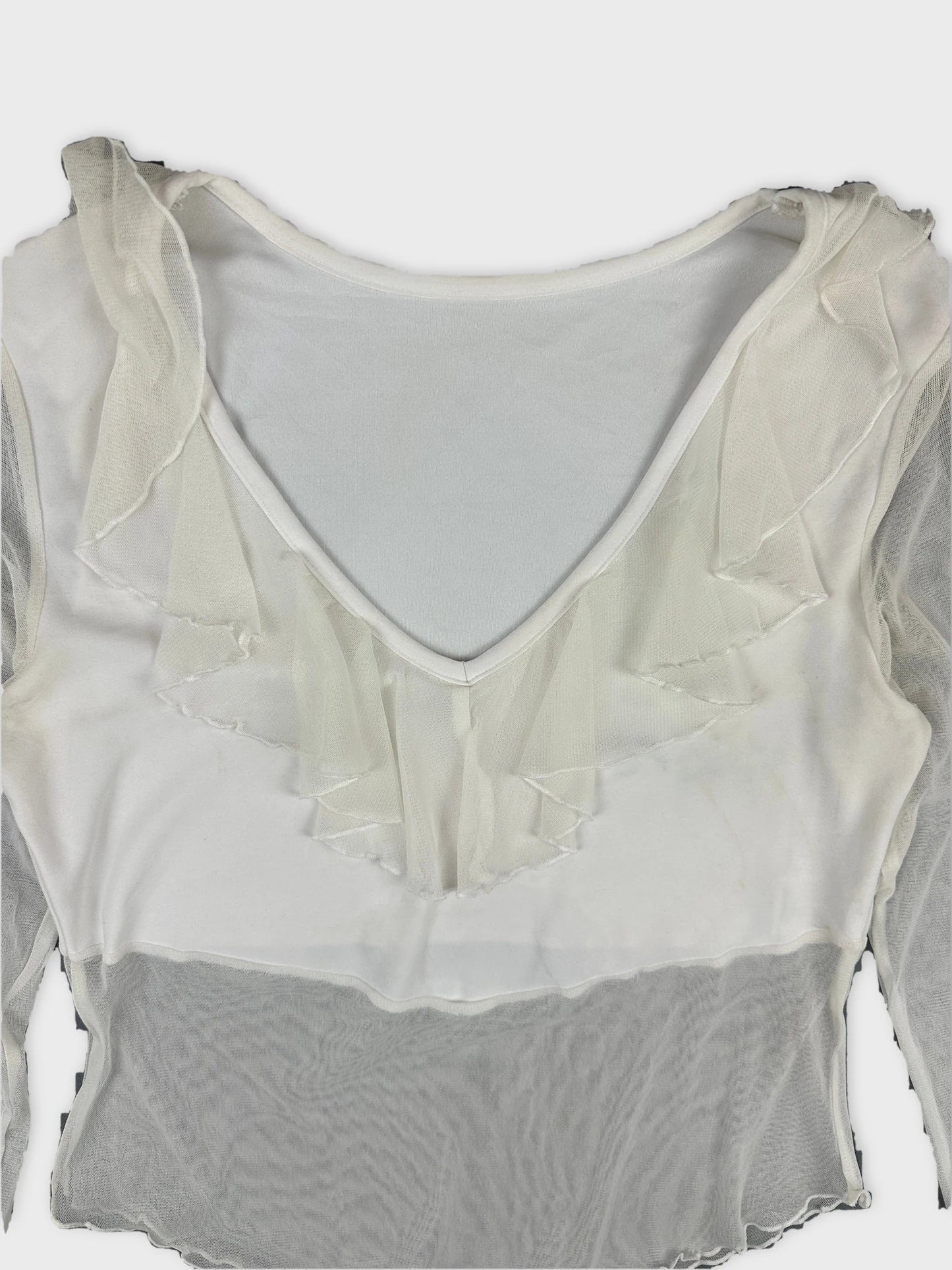 Detail view of a white body shirt featuring ruffled trim