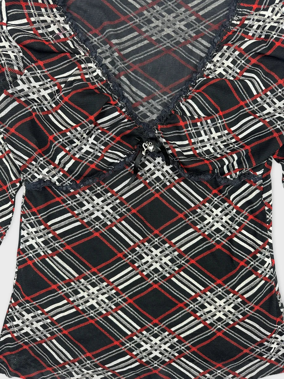 Detail view of a black body shirt featuring a red and white plaid pattern.