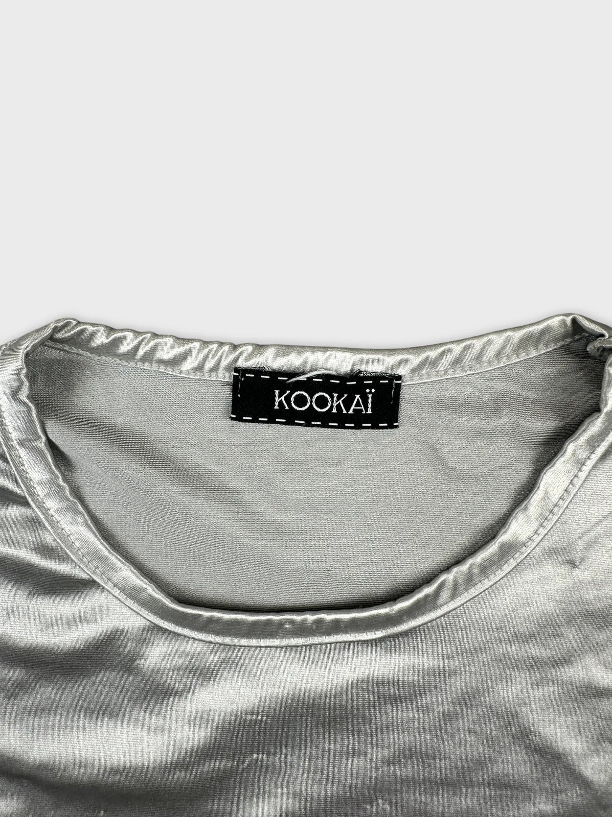 Detail view of a silver body shirt showcasing a smooth texture and rounded neckline.