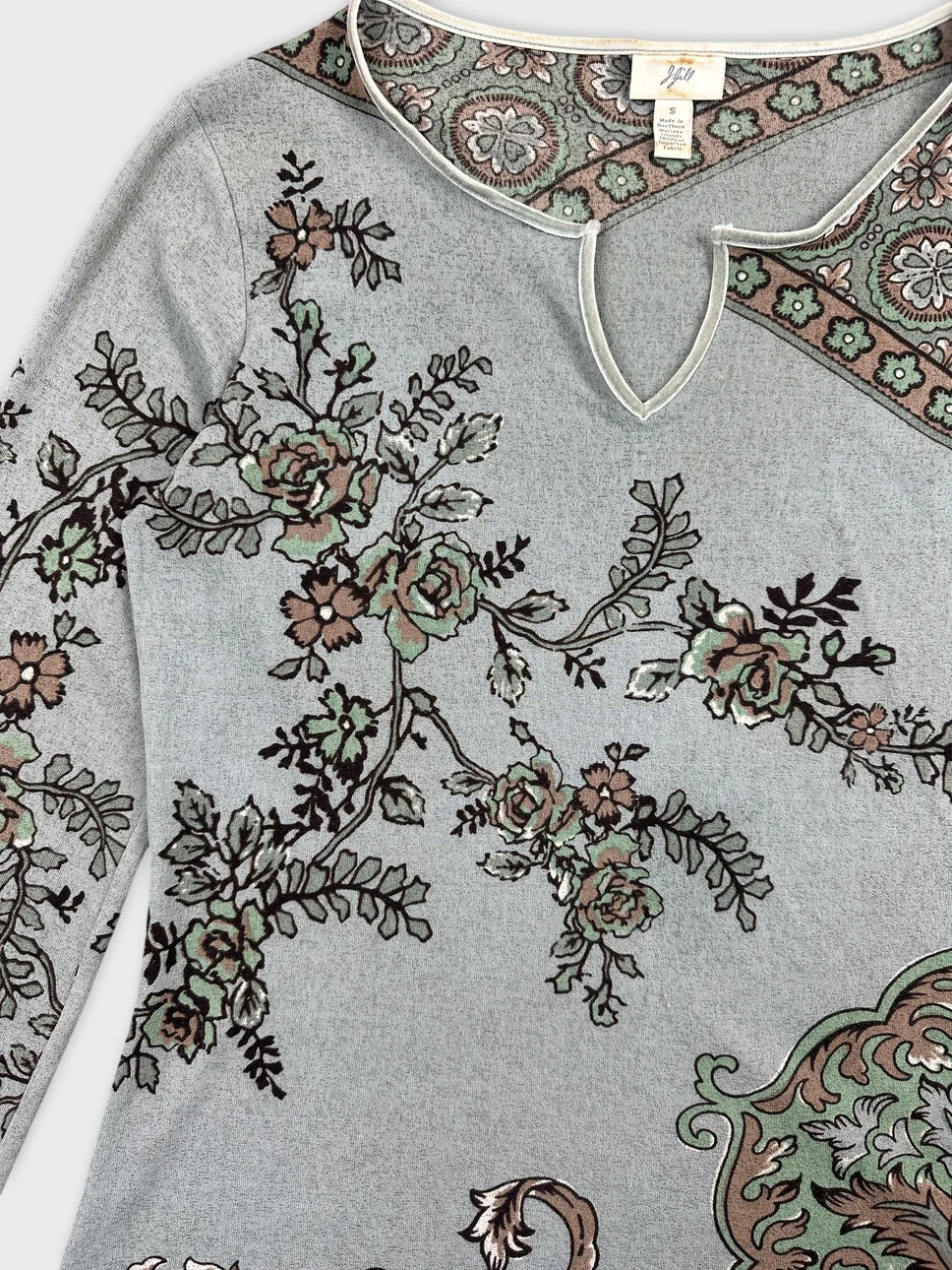 Detail view of a grey body shirt featuring floral prints and a keyhole neckline.