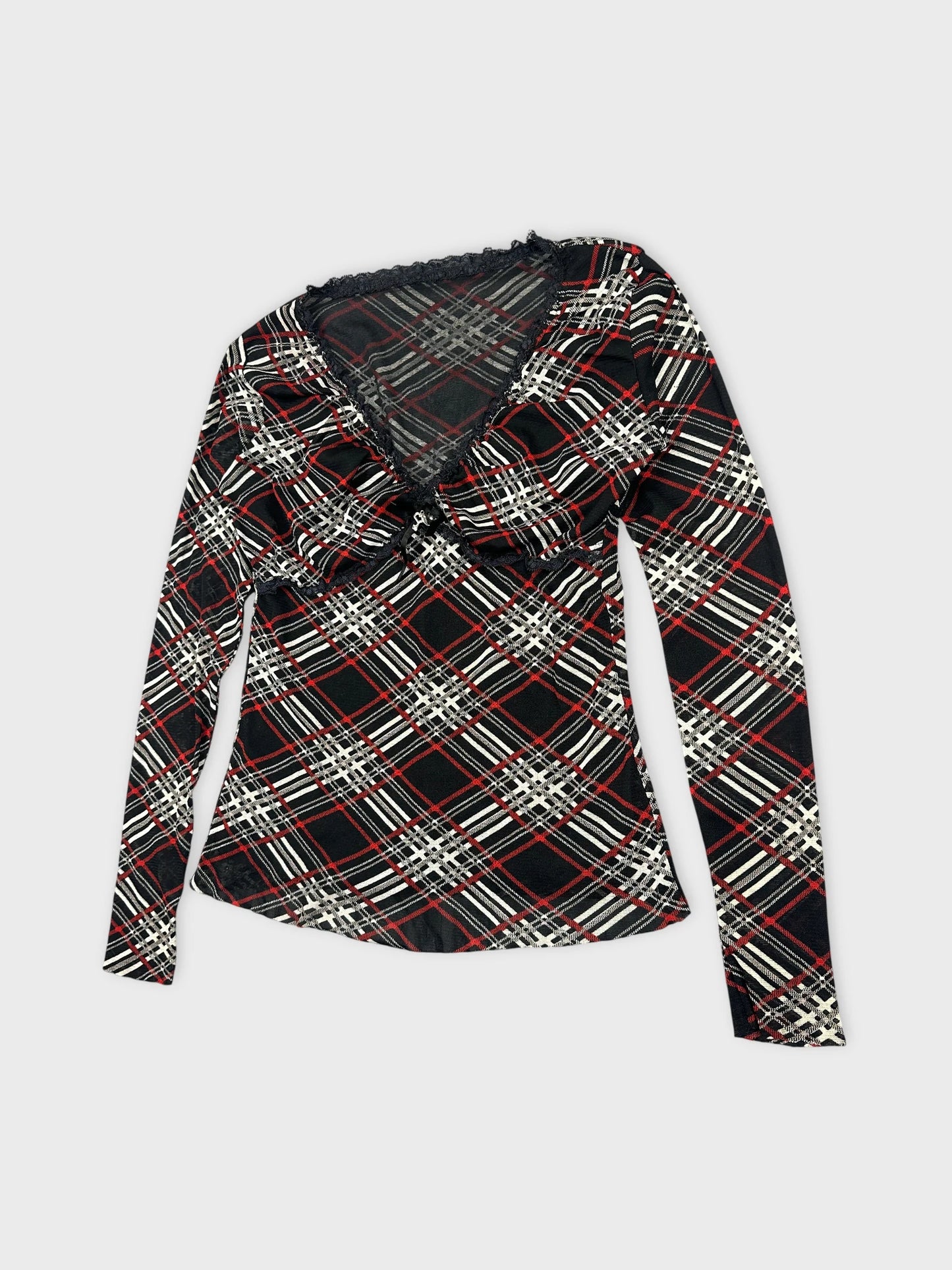 Detail view of a black women's body shirt featuring a plaid pattern with red and white accents.