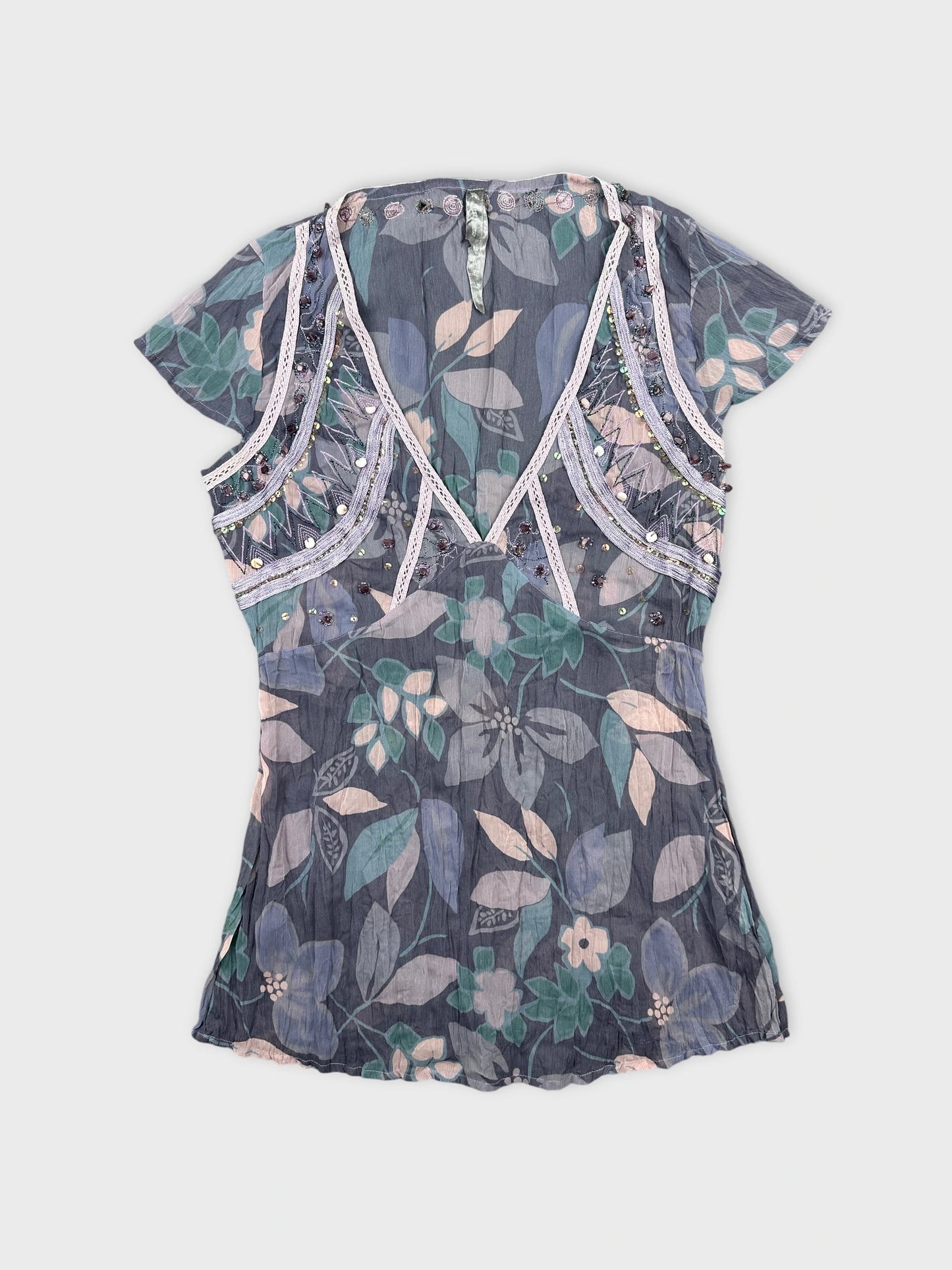 Front view of a floral patterned women body shirt in muted blue tones.