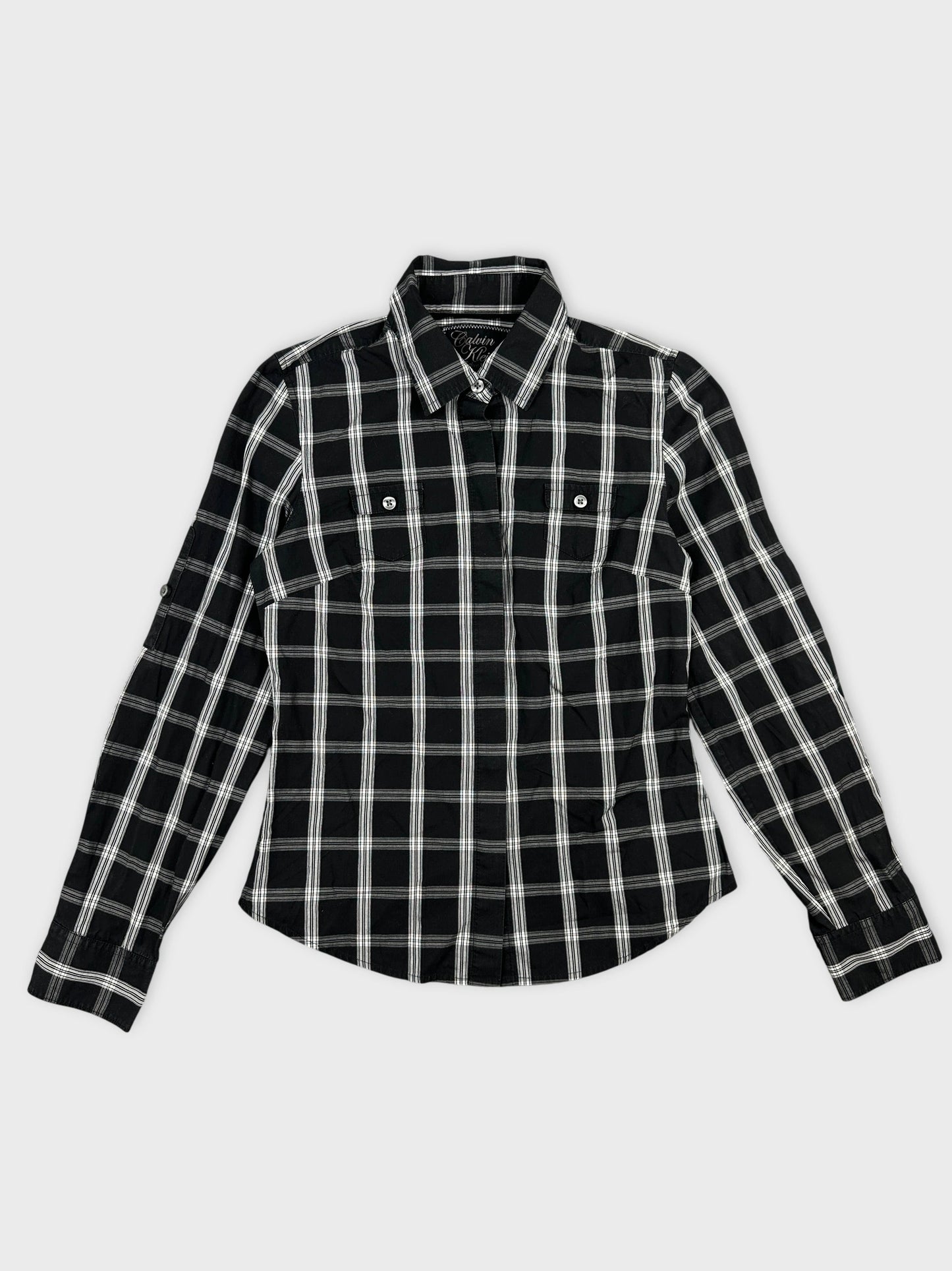Front view of a black and white plaid button-up shirt for women.