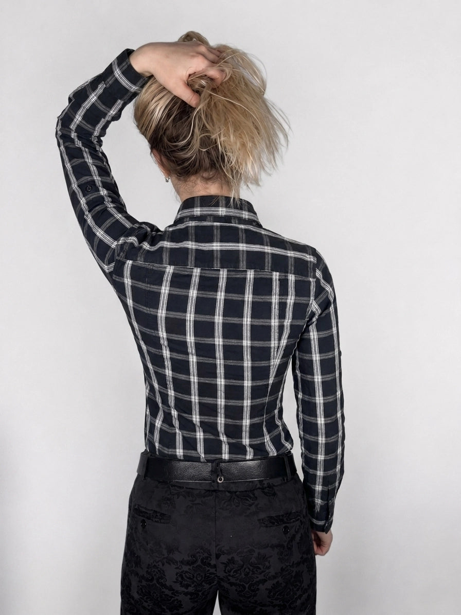 Back view of a black and white plaid long-sleeve shirt.