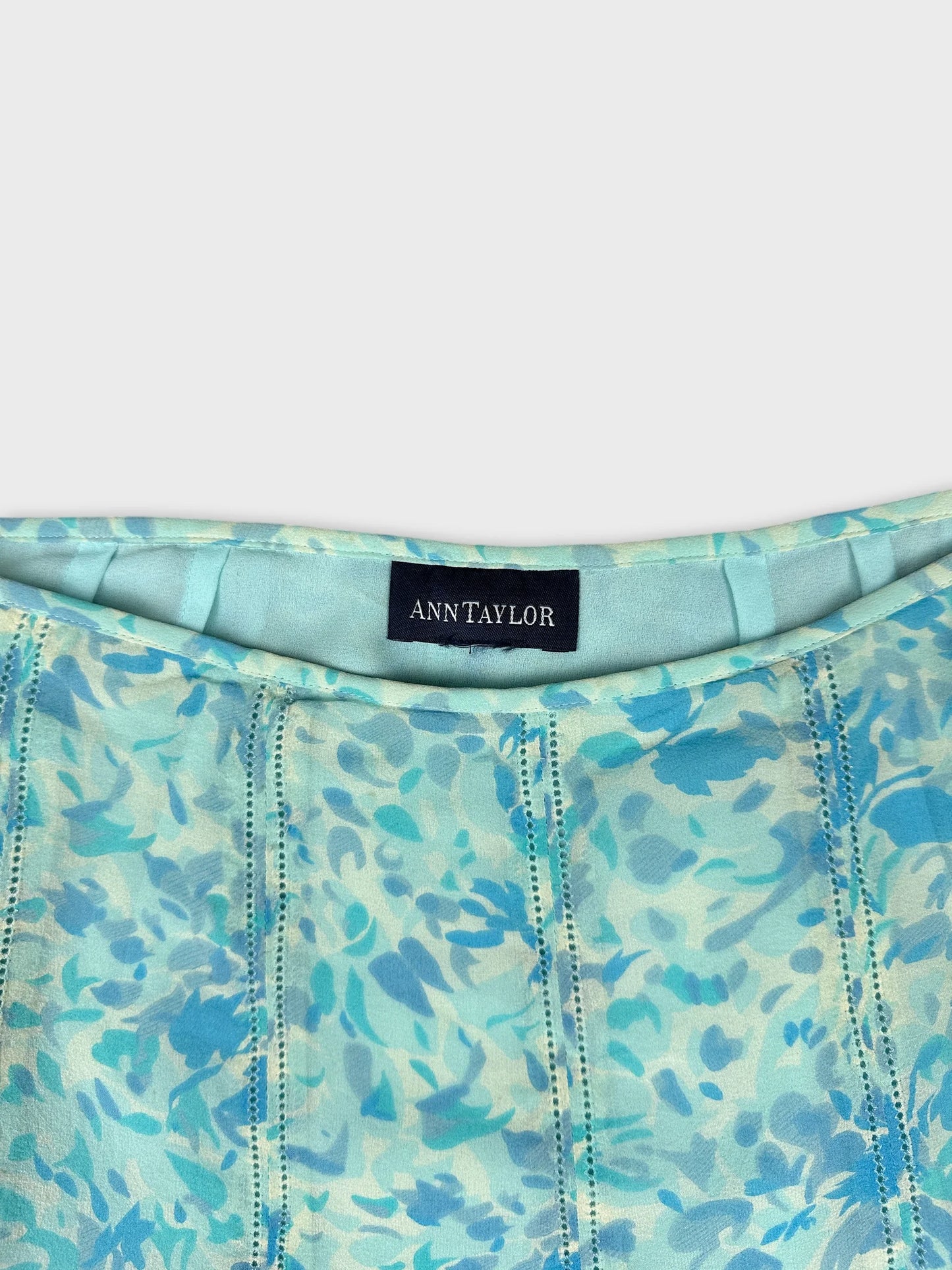 Detail view of a mint green floral print dress with delicate stitching.