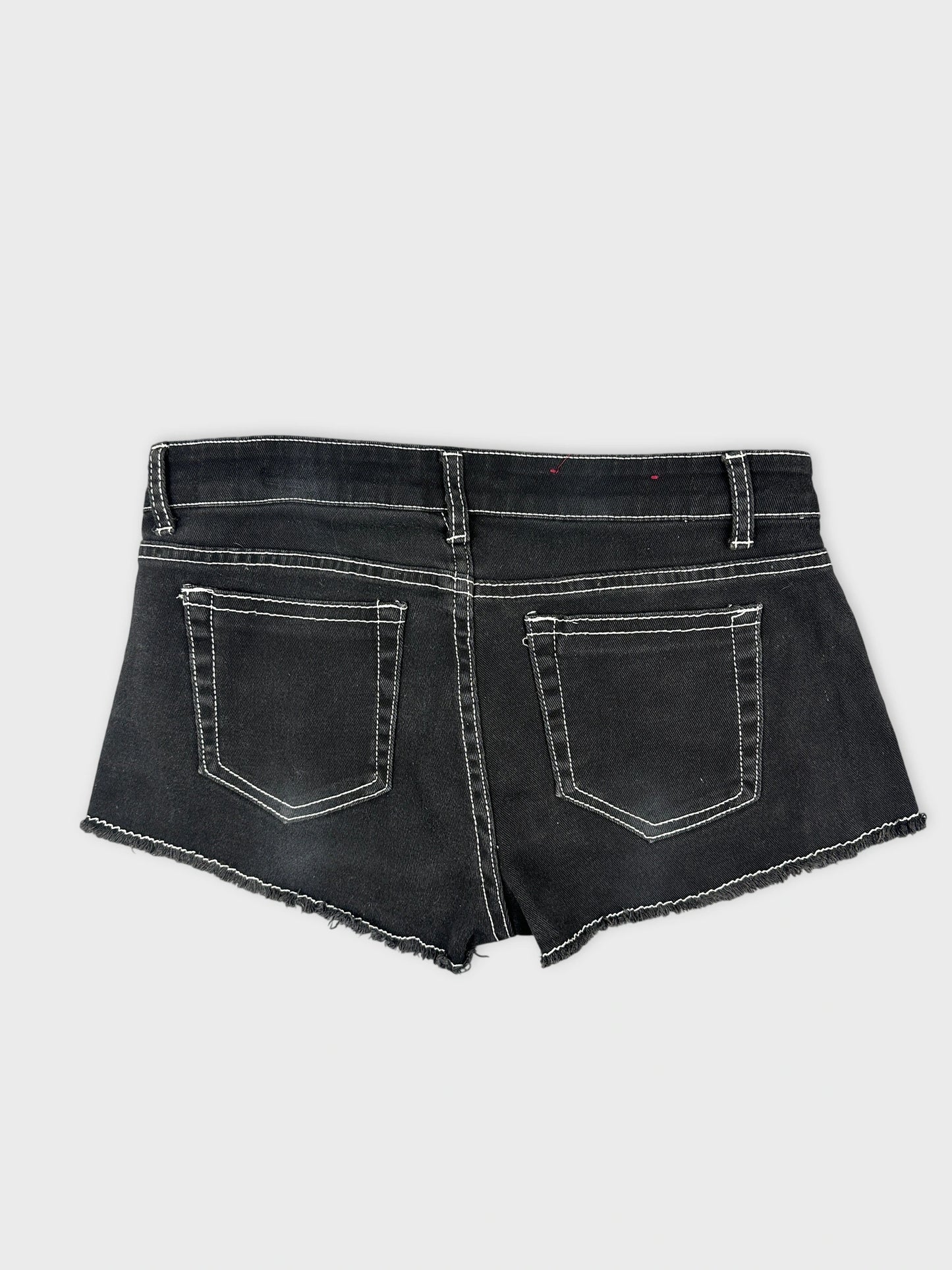 Back view of black denim mini shorts with white stitching and two pockets.