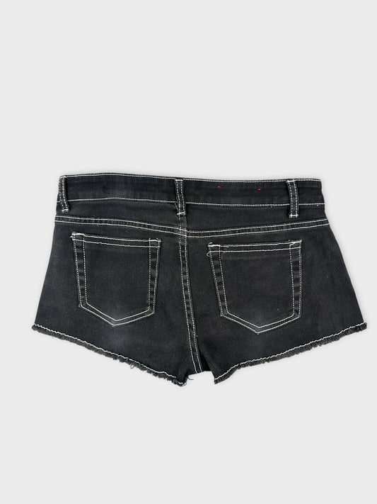 Back view of black denim mini shorts with white stitching and two pockets.