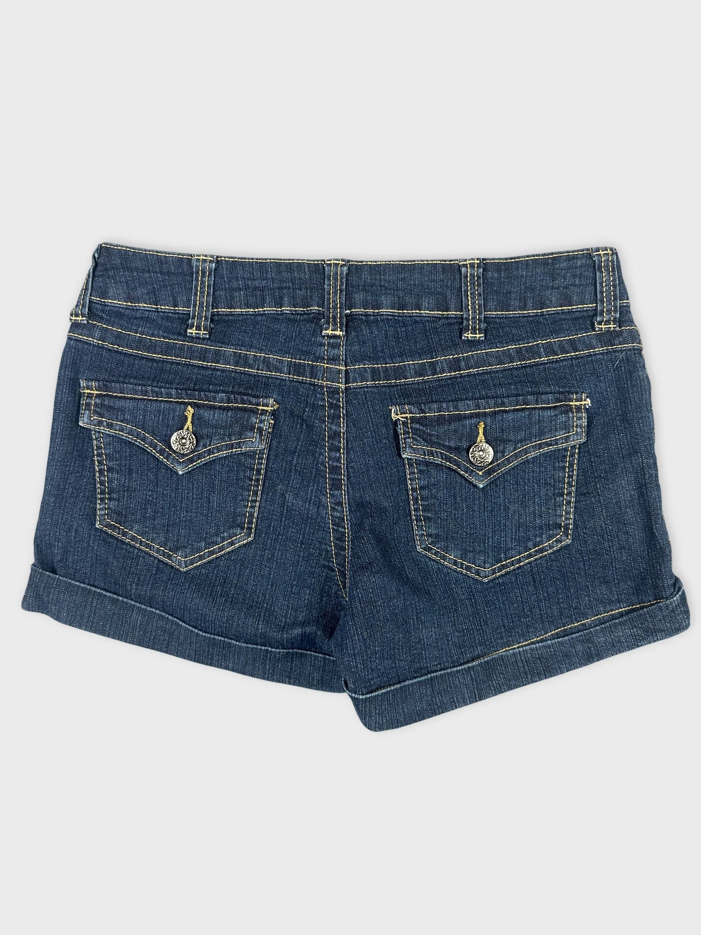 Back view of dark denim shorts featuring stitched pockets and rolled cuffs.
