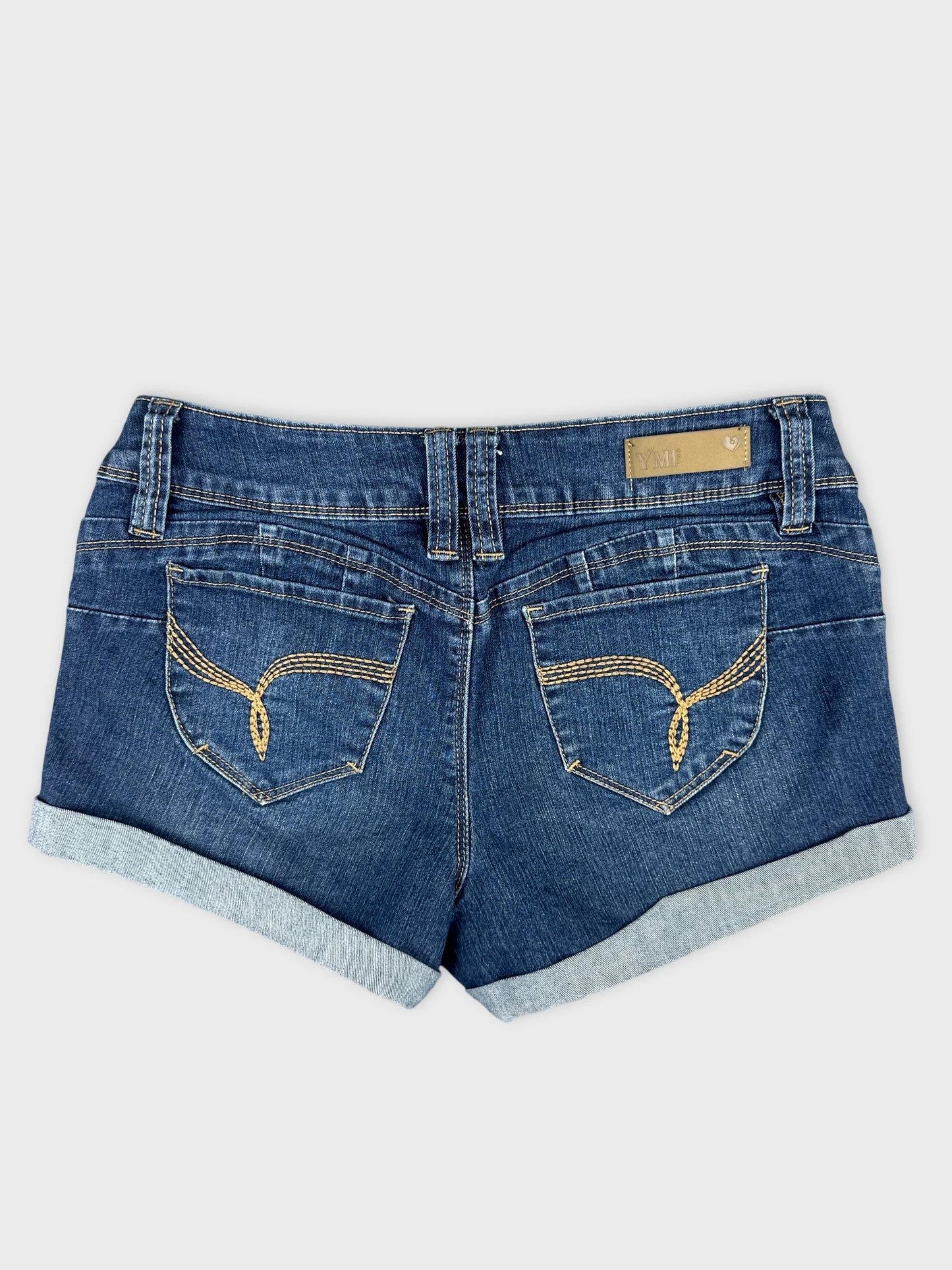 Back view of blue denim mini shorts with detailed stitching on pockets.