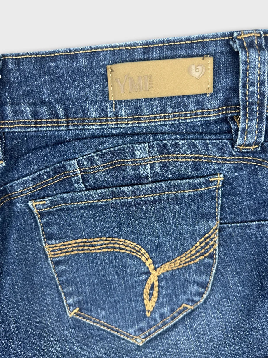 Detail view of blue denim mini shorts with contrasting stitching and back pocket design.