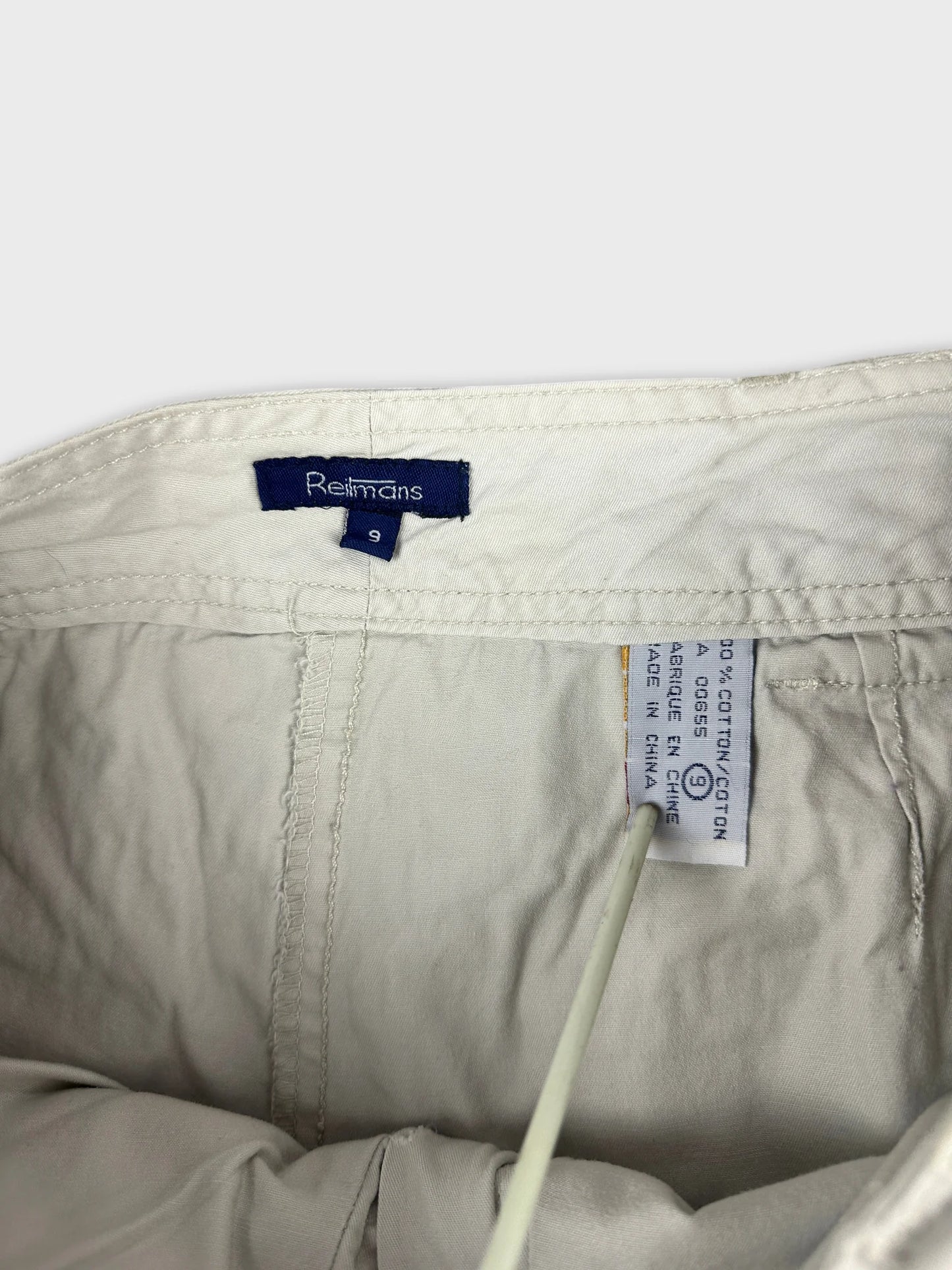 detail view of women mini skirt in light beige with waistband tag visible