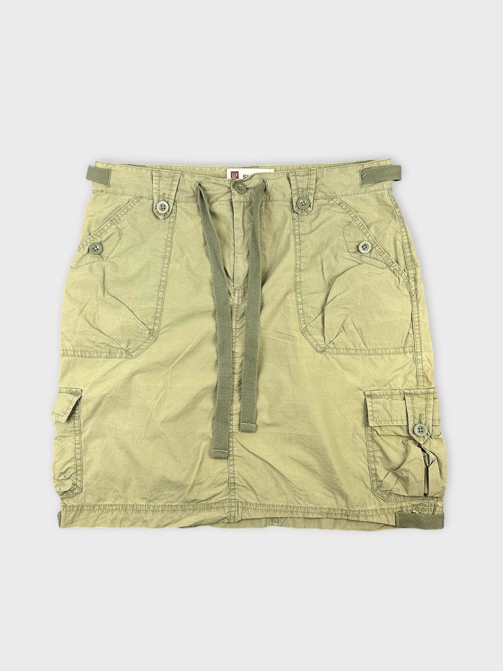 Front view of a green mini skirt featuring cargo pockets and drawstring detailing.