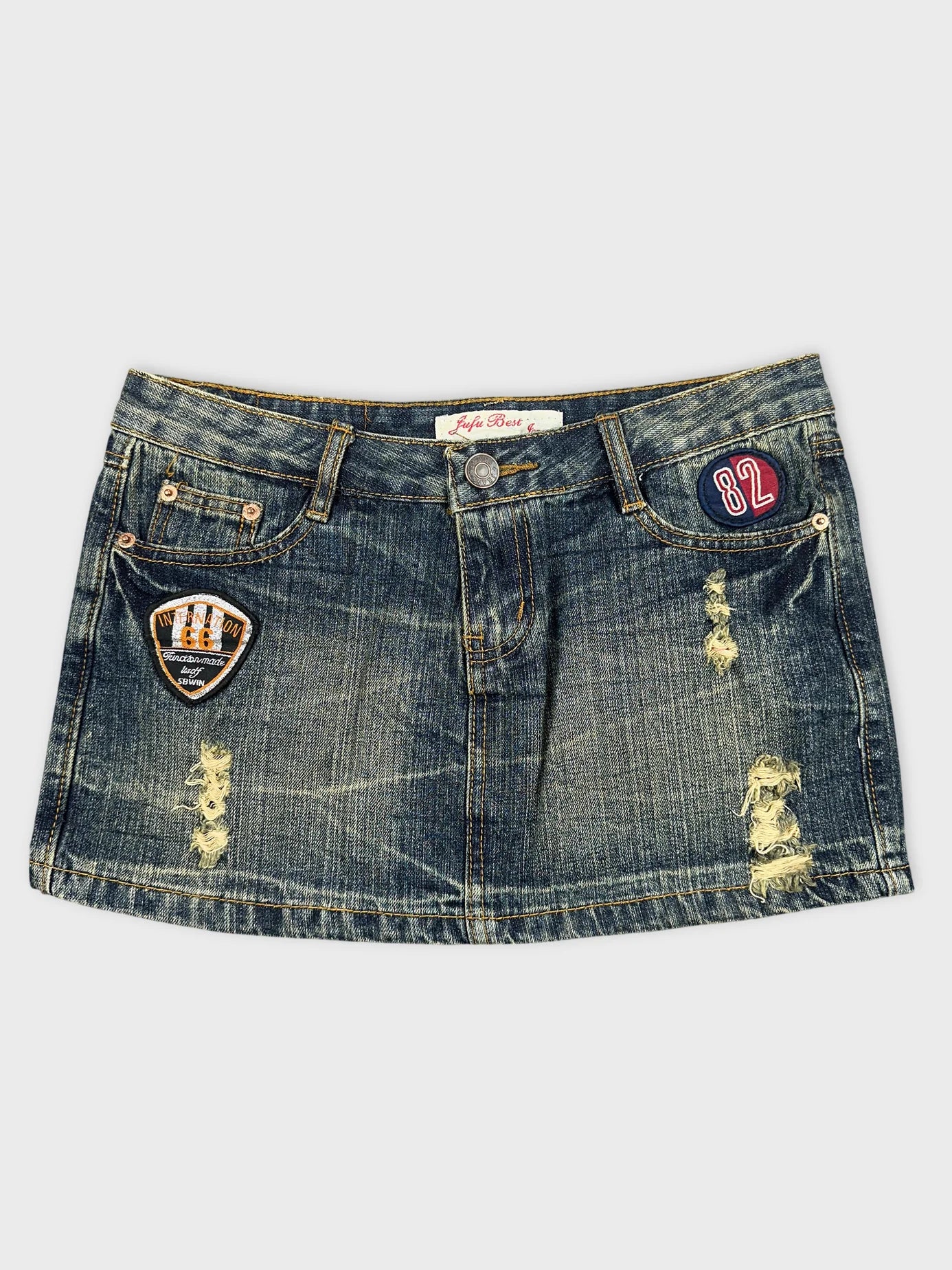 Front view of a mini denim skirt featuring patches and distressed details.