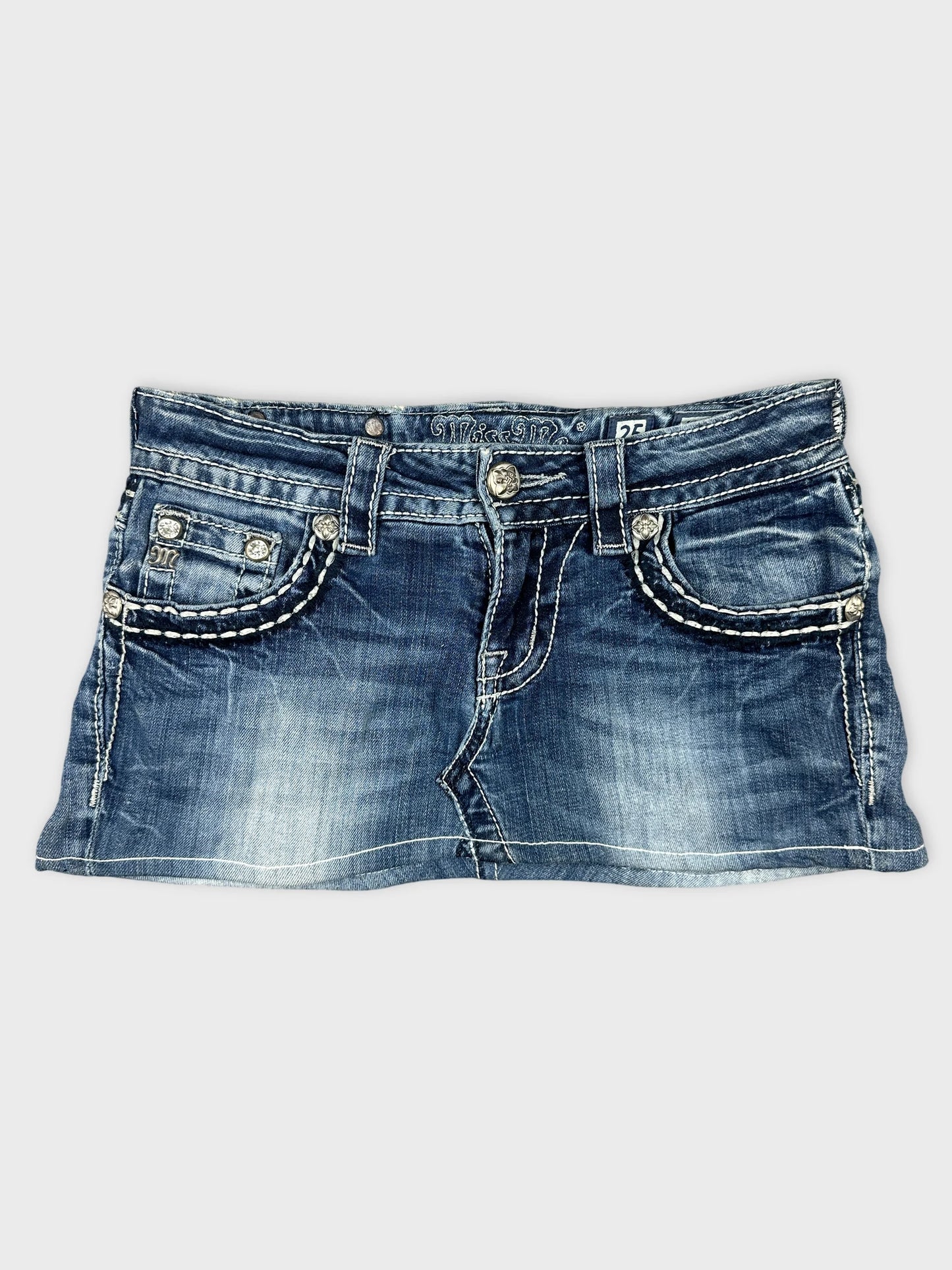 Front view of denim mini skirt featuring embellished pockets and white stitching.