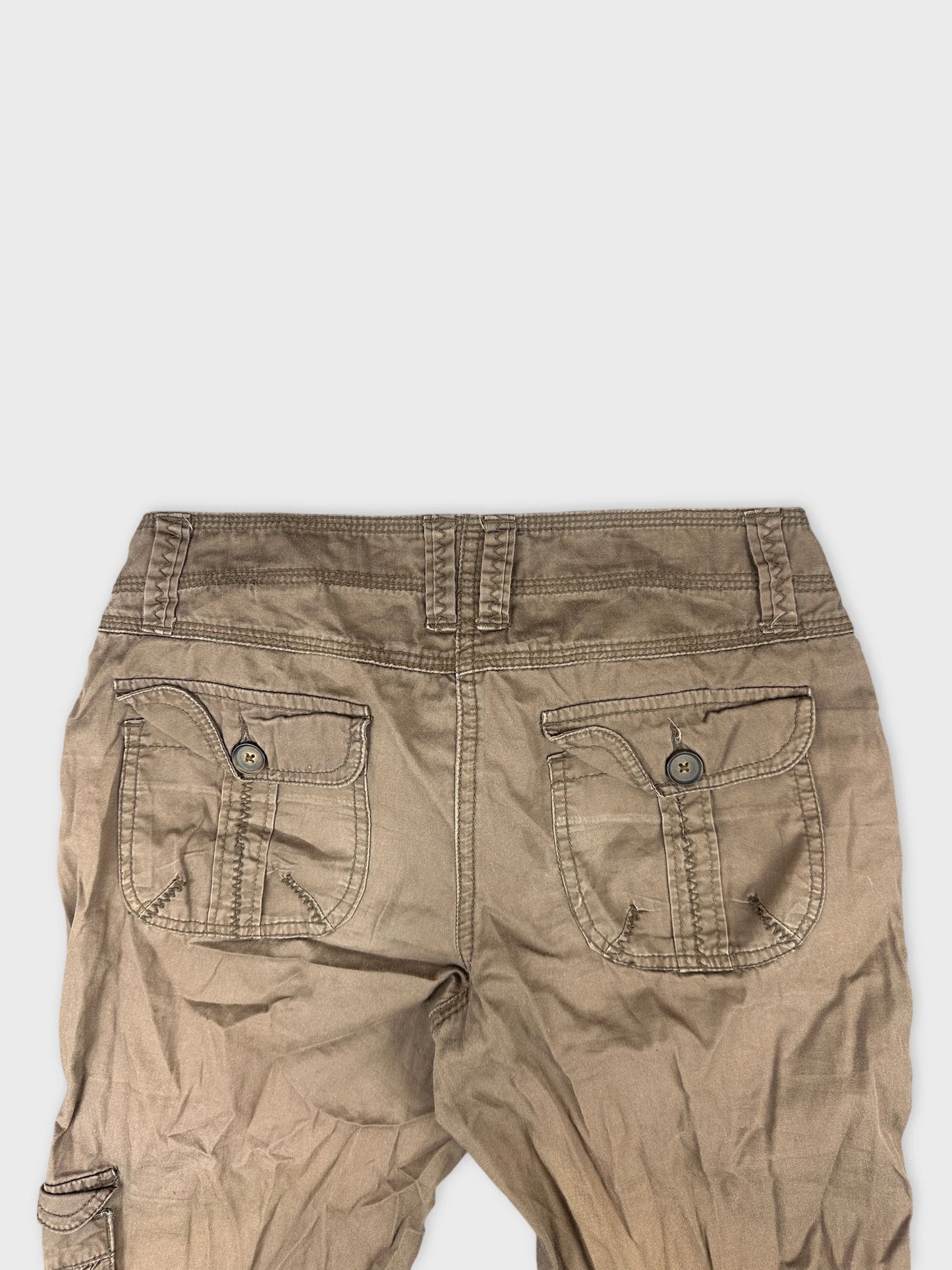 Detail view of brown cargo shorts with buttoned back pockets.