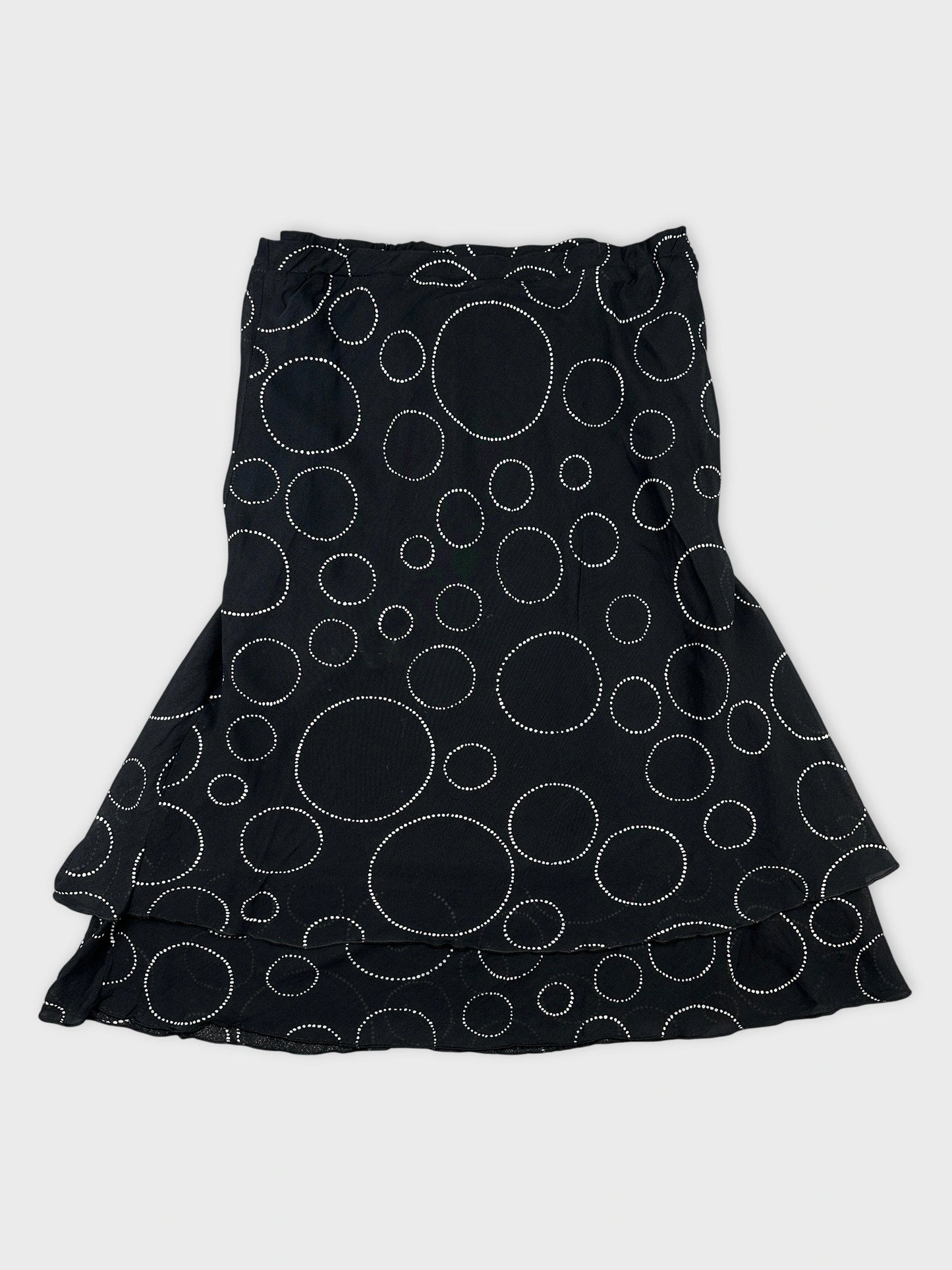 Back view of a black skirt with white polka dot pattern.