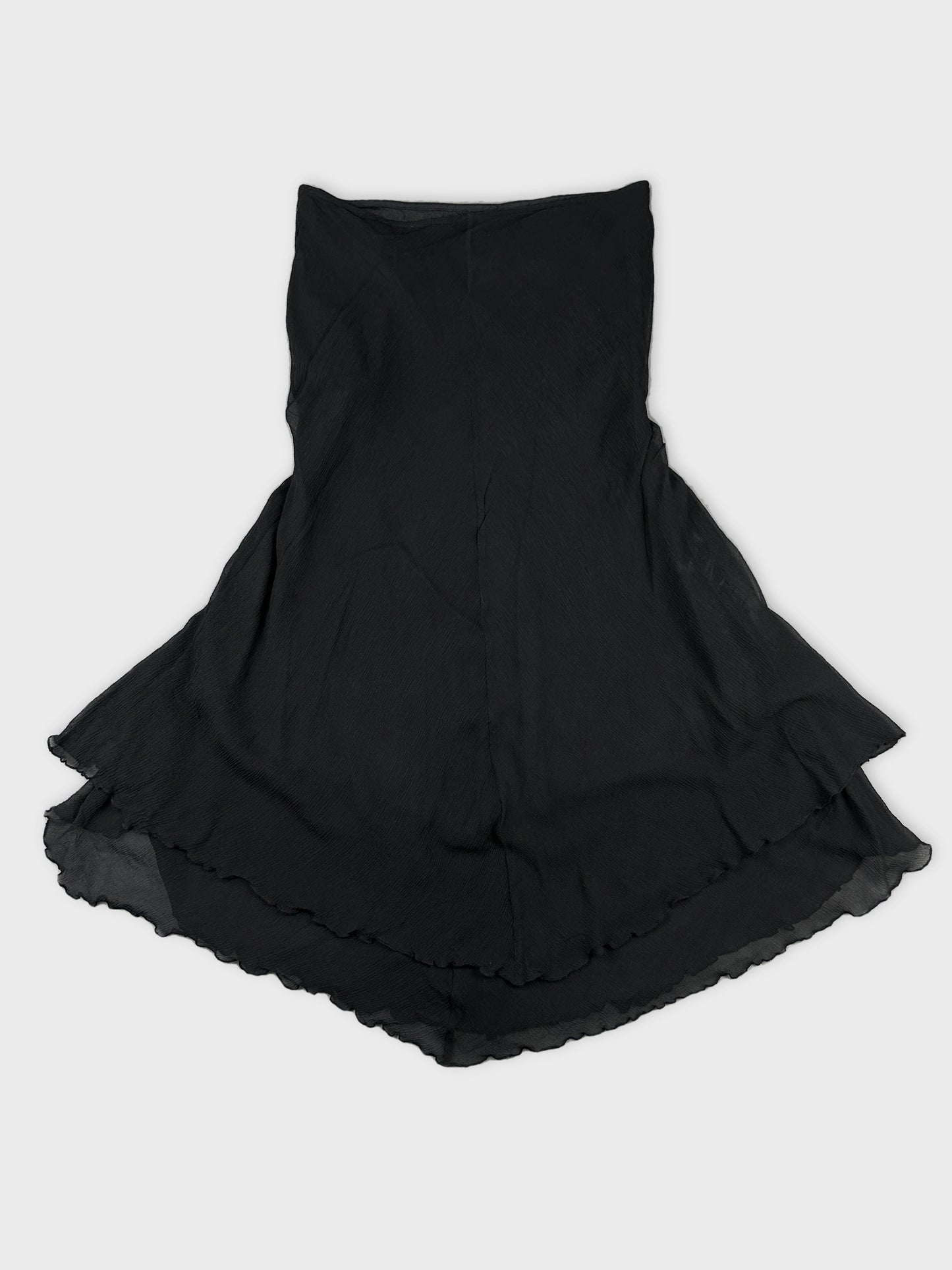 Back view of a black skirt with a ruffled hemline.