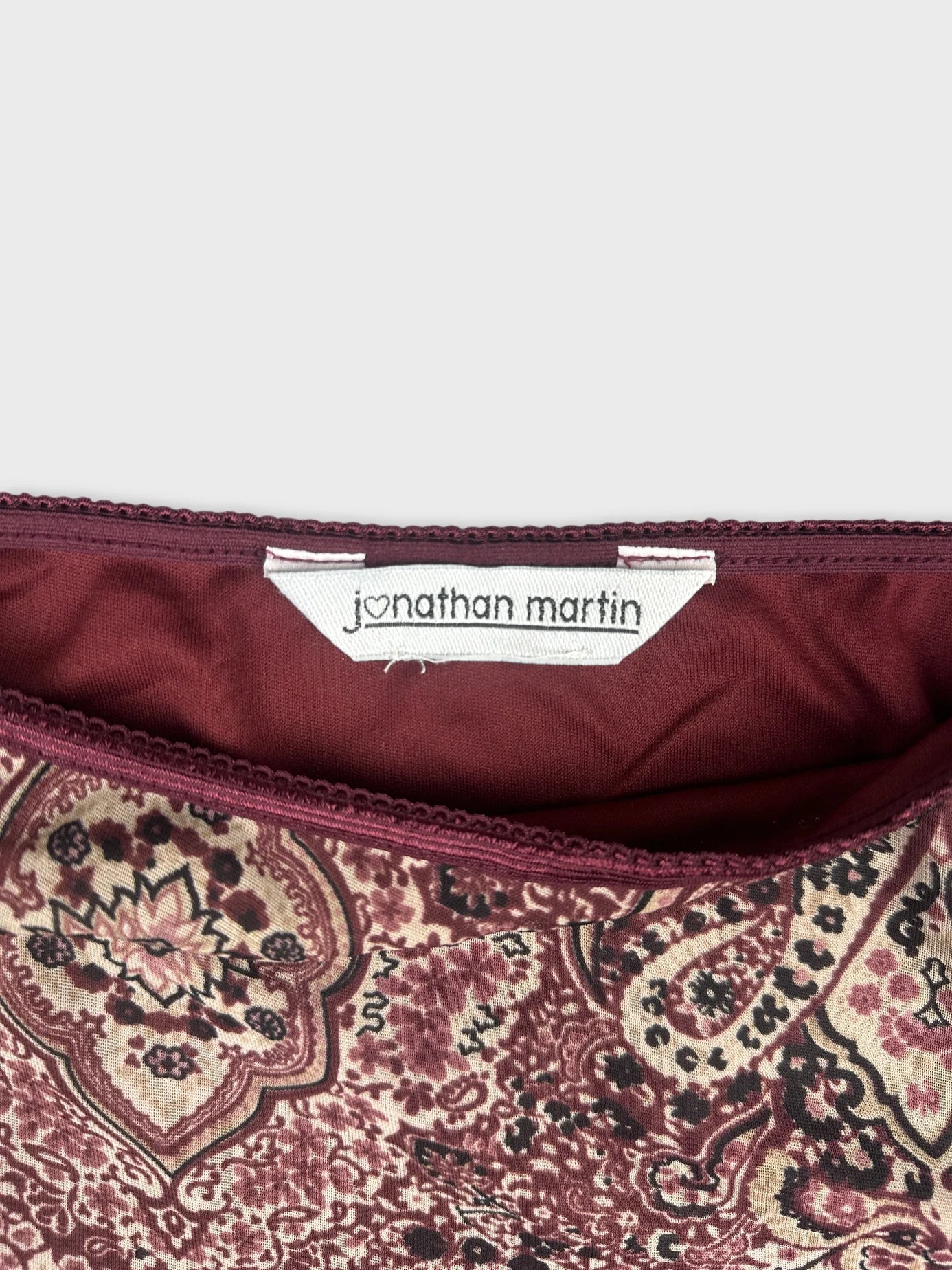 Detail view of women's skirt in burgundy with paisley pattern