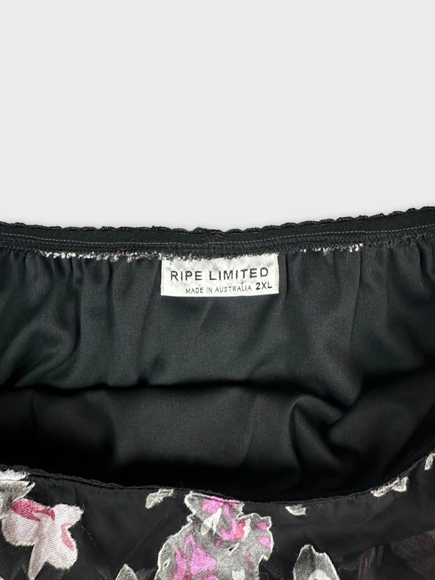 Detail view of a black skirt featuring floral print and elastic waistband.