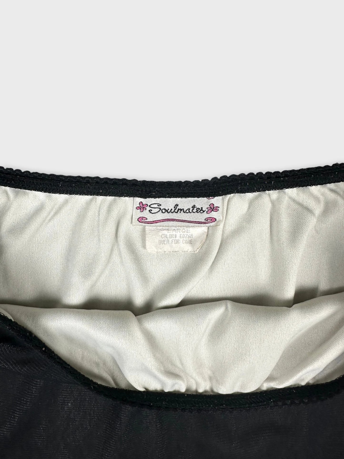 Detail view of a black women's skirt featuring a textured waistband.