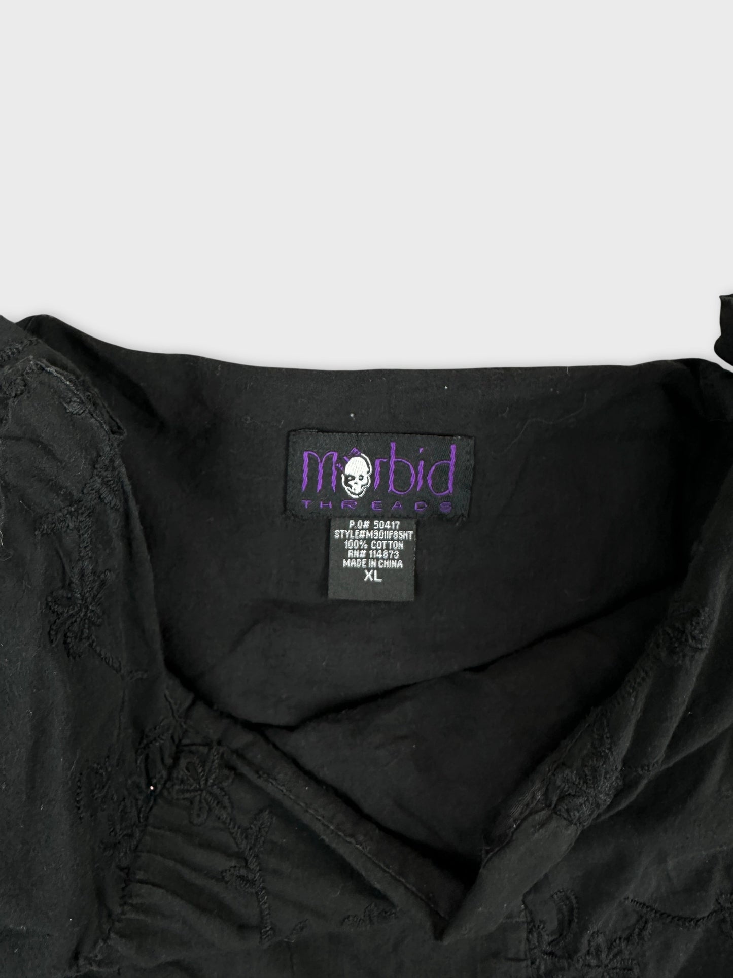 Detail view of a black flower-embroidered skirt's waistband.