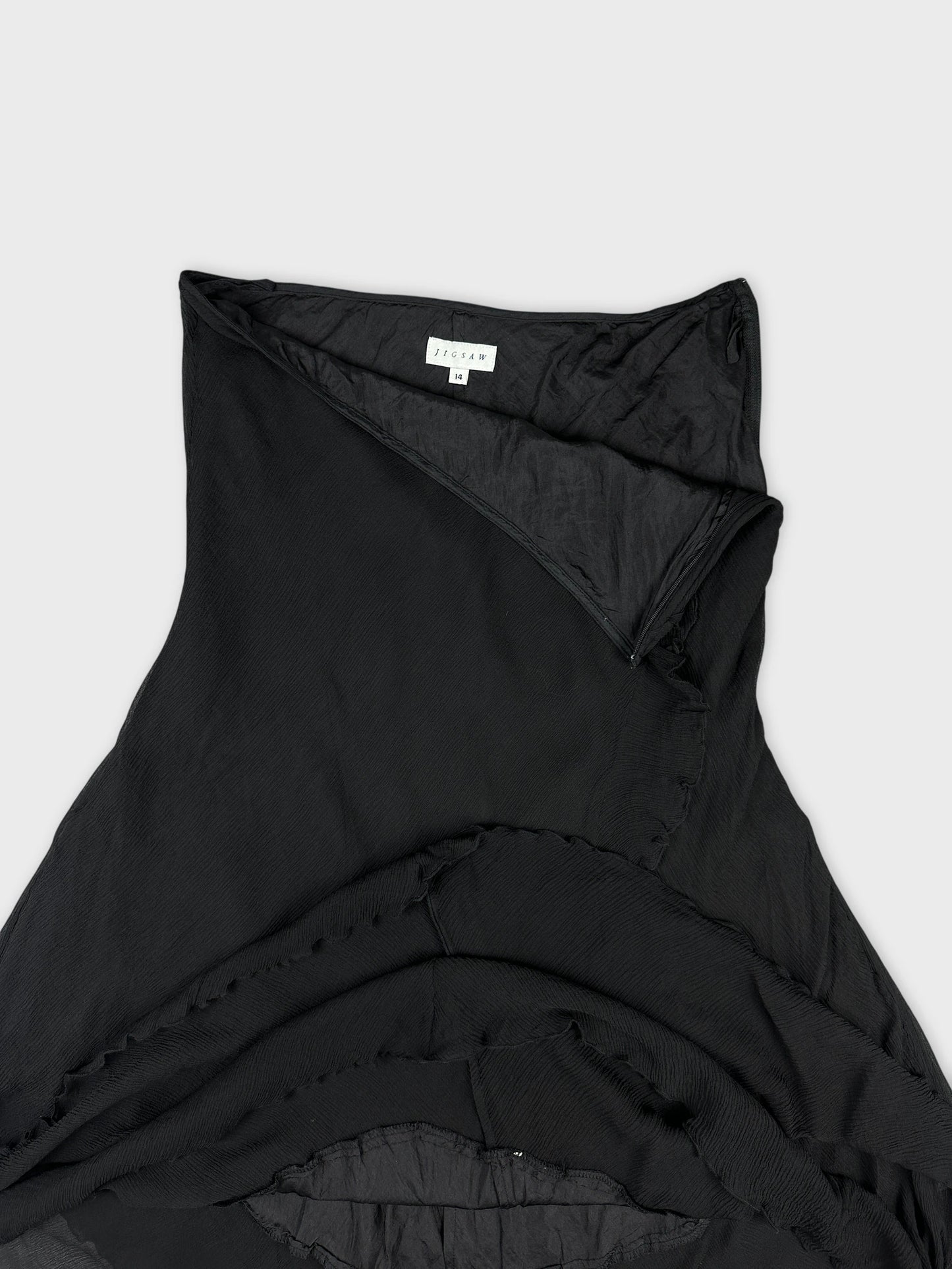 Black skirt detail view showcasing ruffled edges and smooth fabric texture.