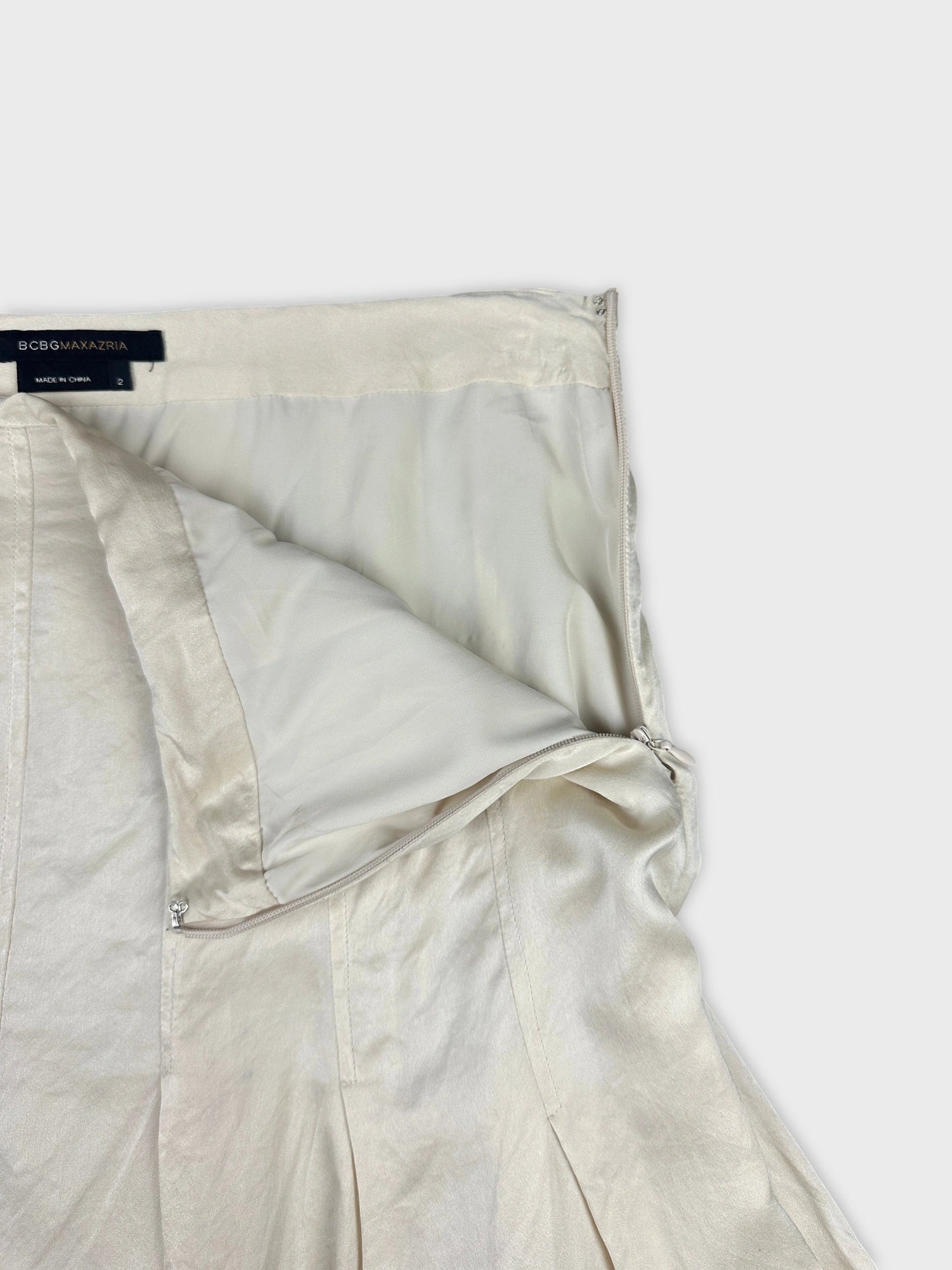 Detail view of a light cream women's skirt featuring a zip closure.
