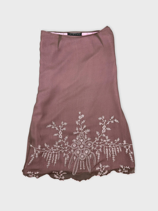 Front view of a vintage brown skirt with floral embroidery detail.