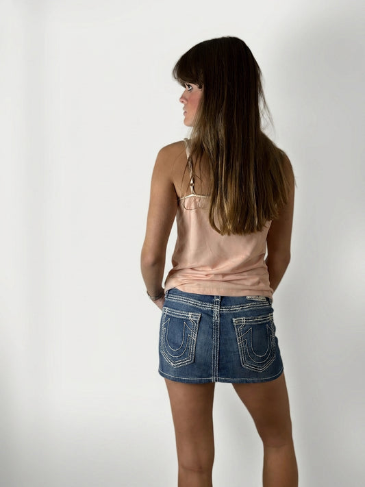 Back view of a denim skirt featuring distinctive stitched back pockets.