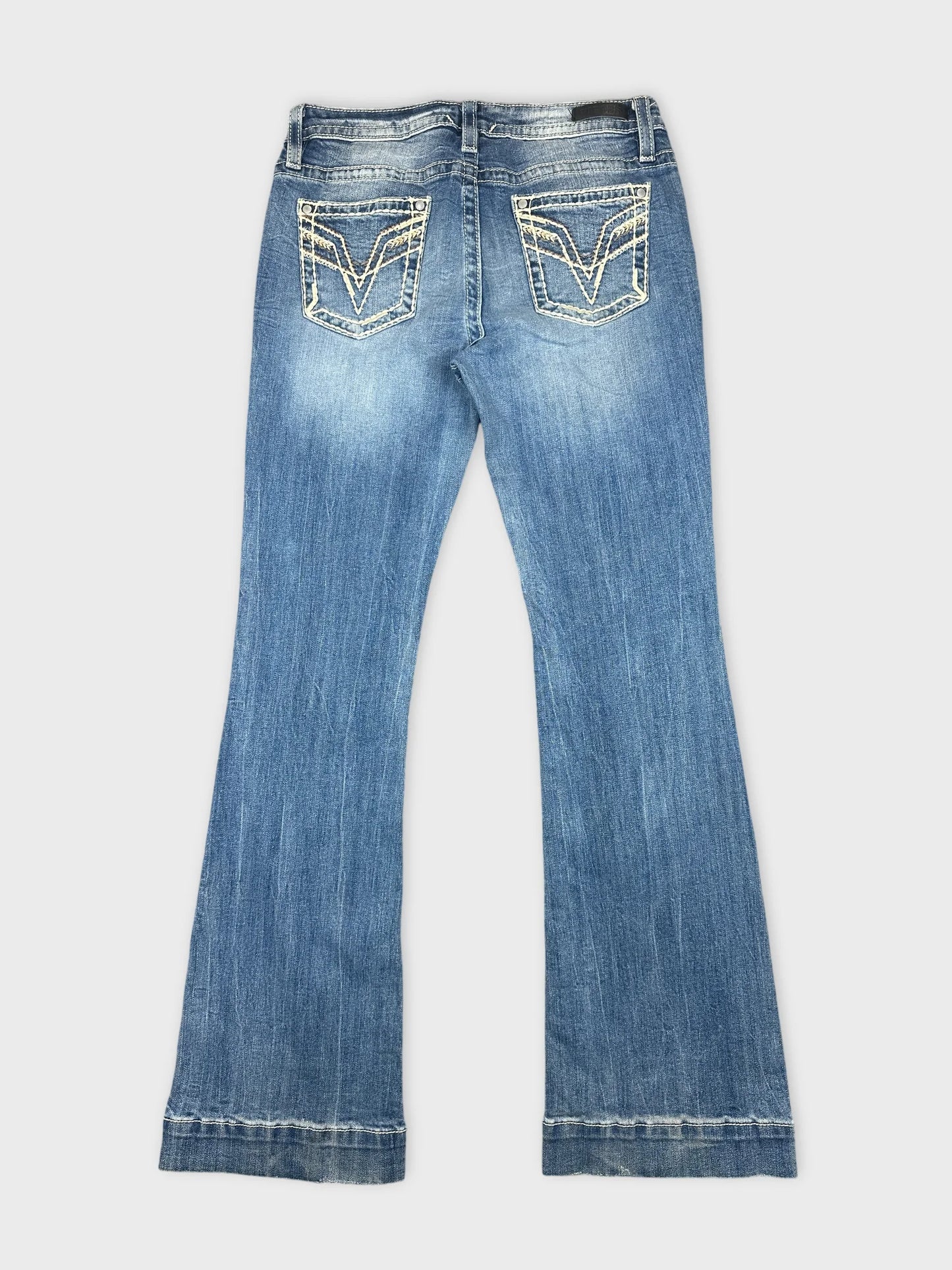 Back view of blue denim jeans with decorative stitched pockets