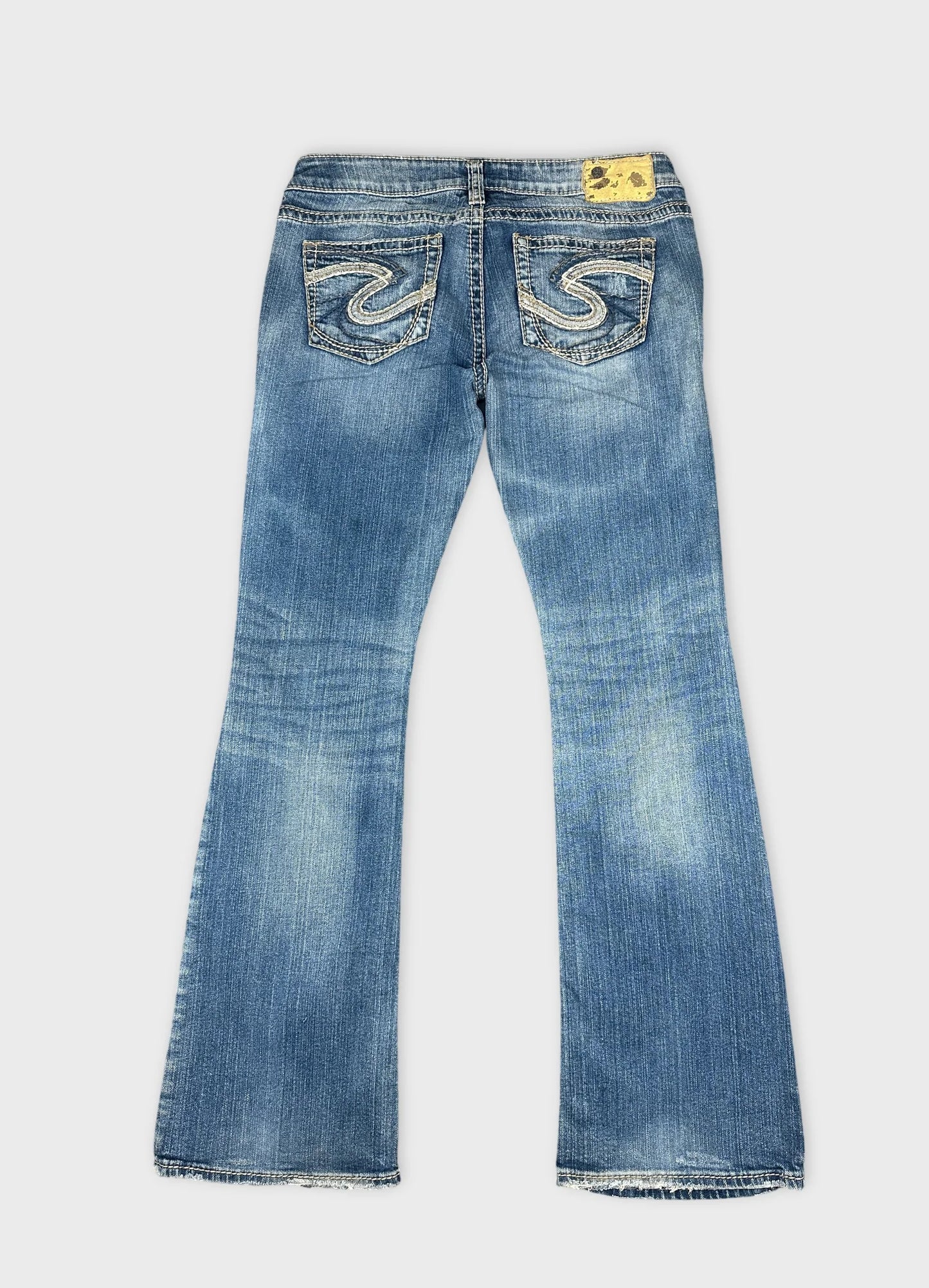 Back view of blue denim jeans with detailed stitching on pockets.