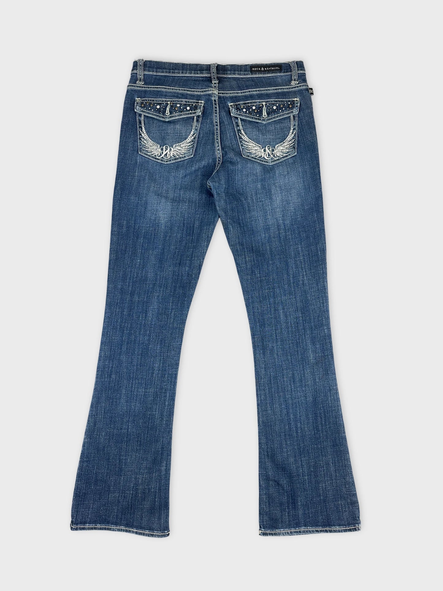 Back view of blue denim jeans featuring embroidered wing details on pockets.