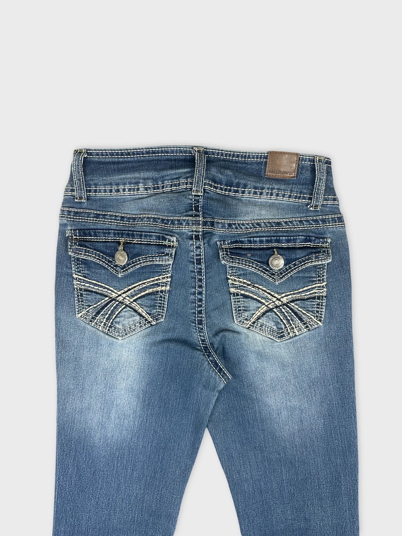 detail view of women denim jeans with blue color and decorative back pockets
