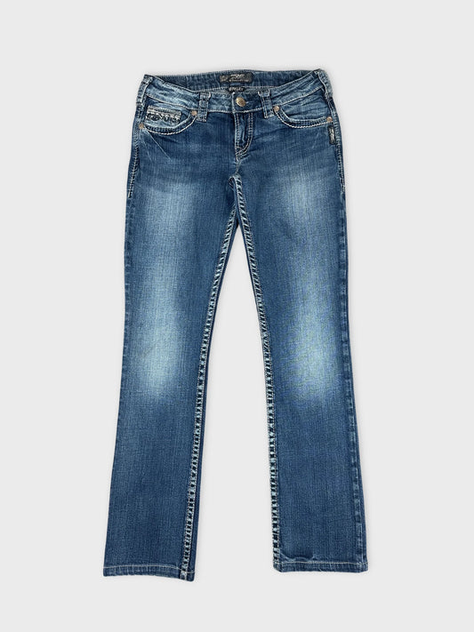 Front view of blue denim jeans with stitched trim detailing.