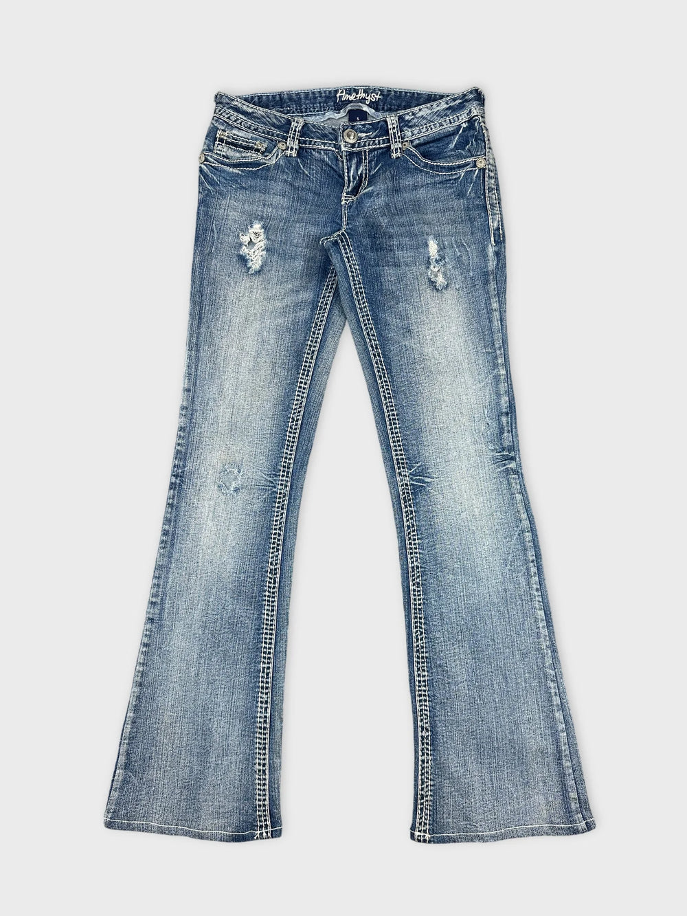 Front view of women denim jeans in light blue with distressed details.