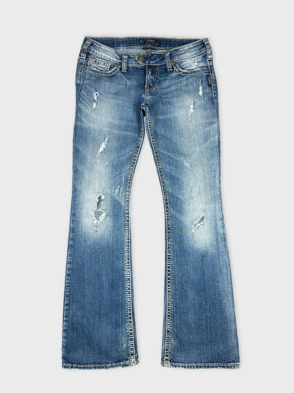 Front view of blue denim jeans featuring distressed details and flared legs.