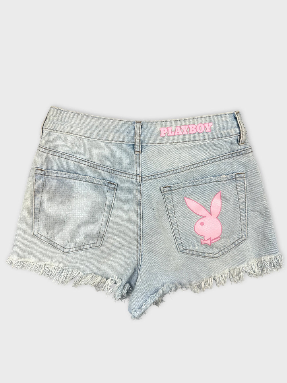 Back view of light blue denim shorts with pink Playboy logo.