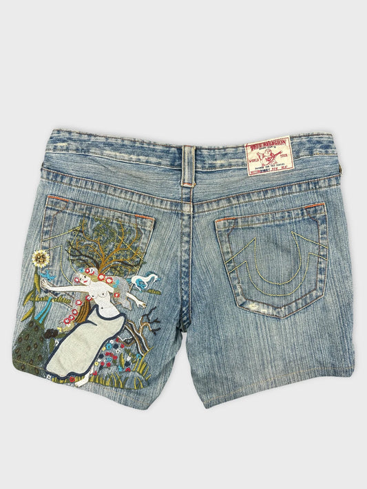 Back view of women denim shorts in light blue with embroidered design.