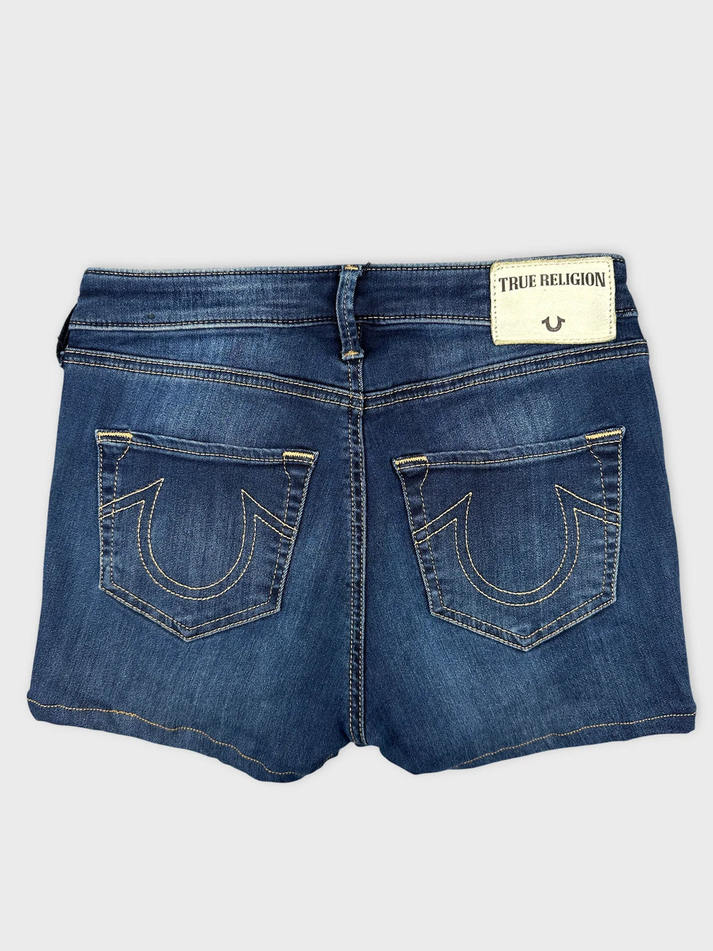 Back view of women denim shorts in dark blue with visible back pockets.