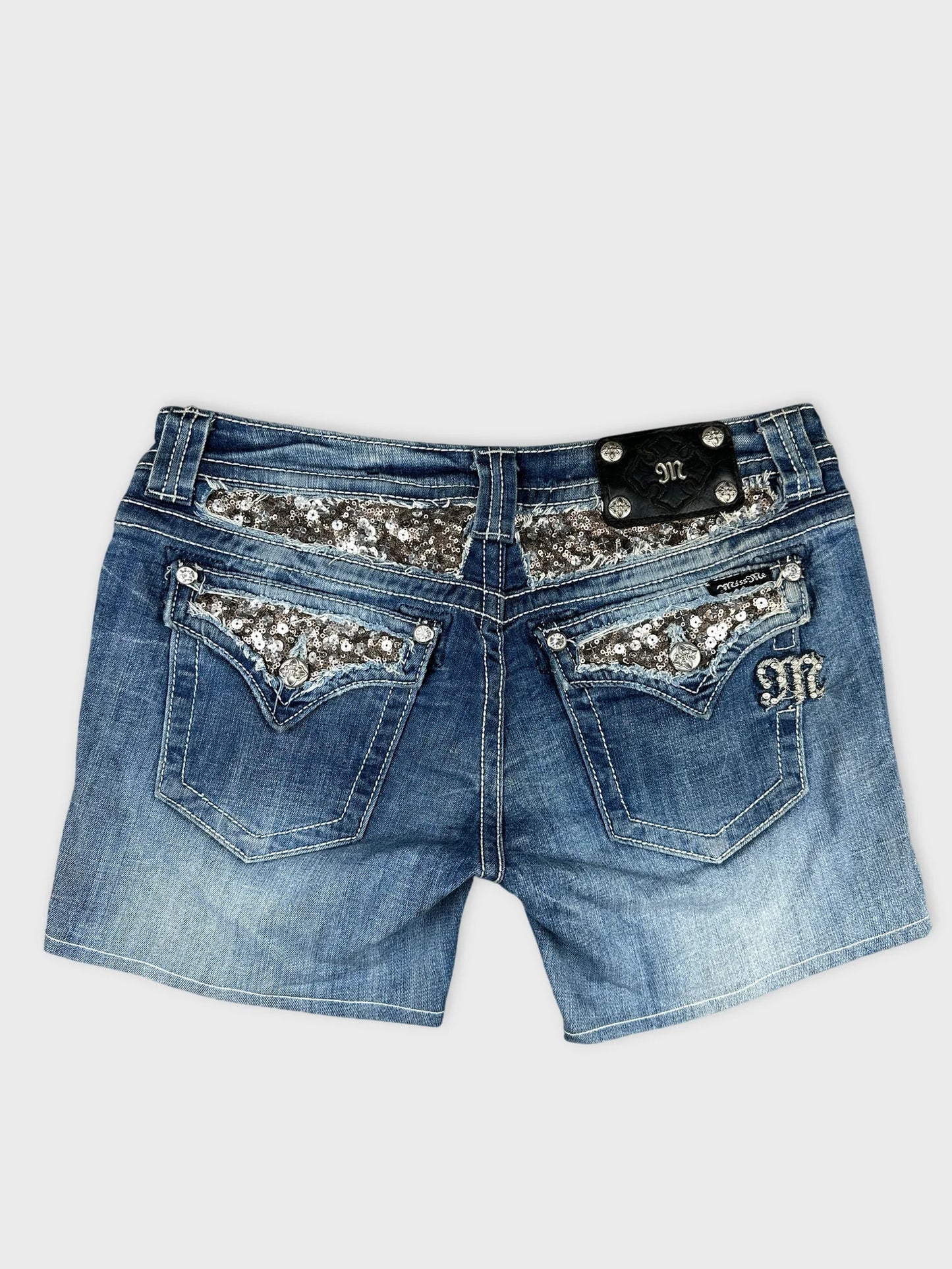 Back view of denim shorts with silver sequin detail on pockets.