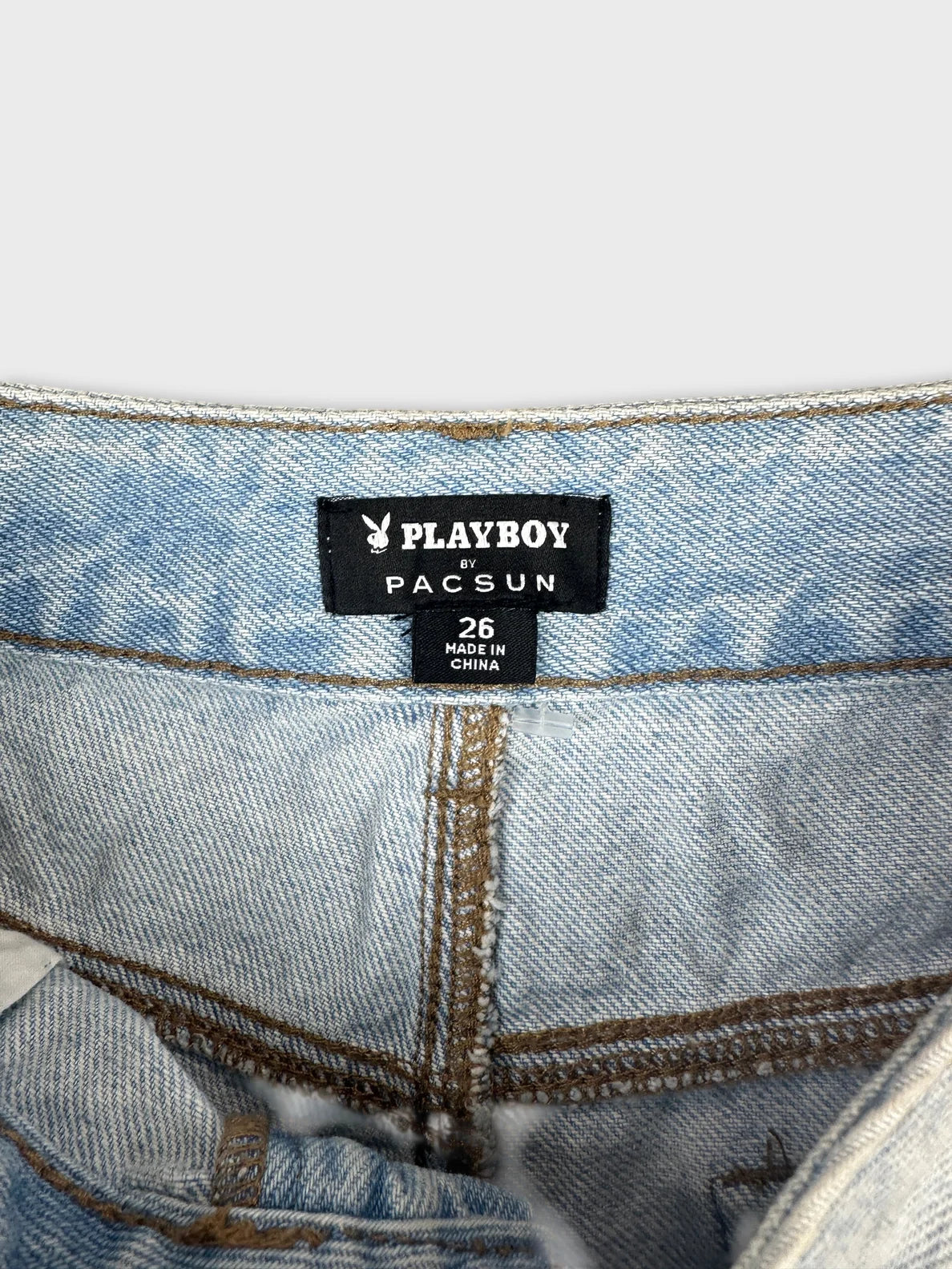 Detail view of denim shorts in light blue with visible stitching.