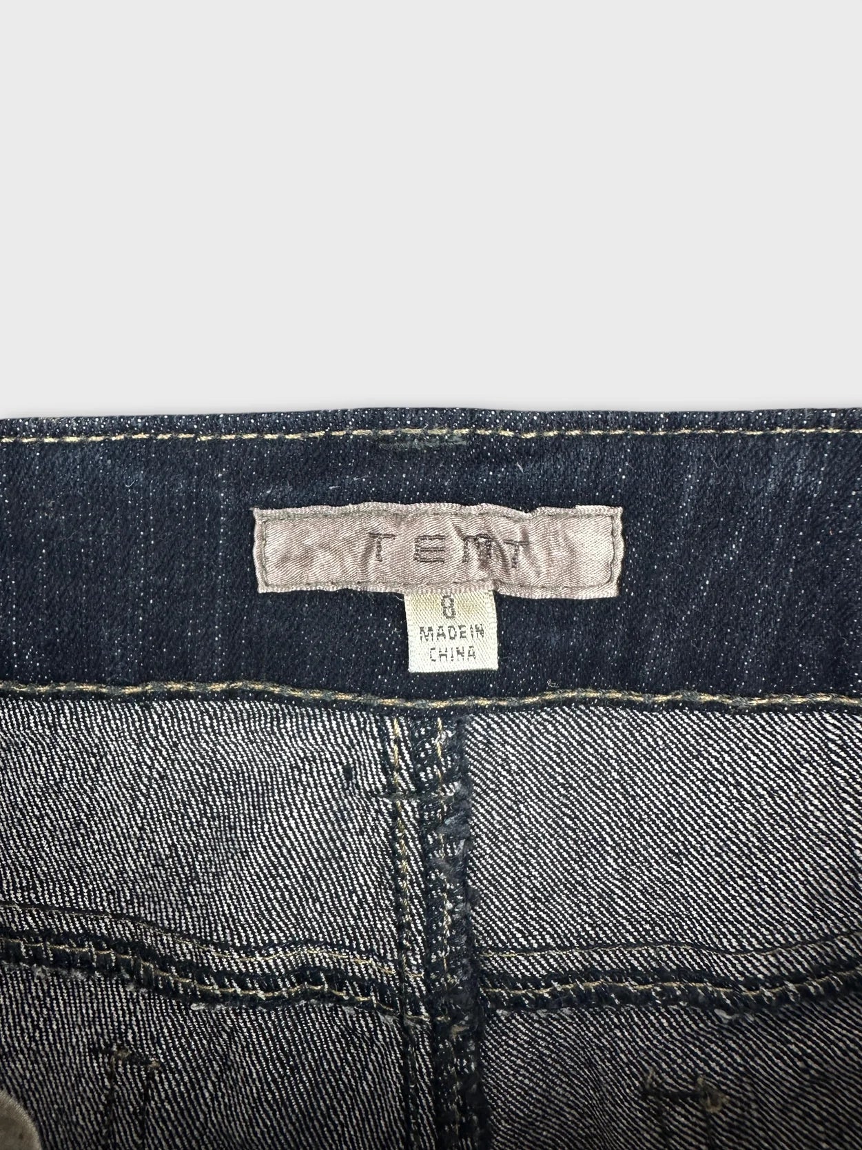 Detail view of women denim shorts showing dark blue color and stitching.