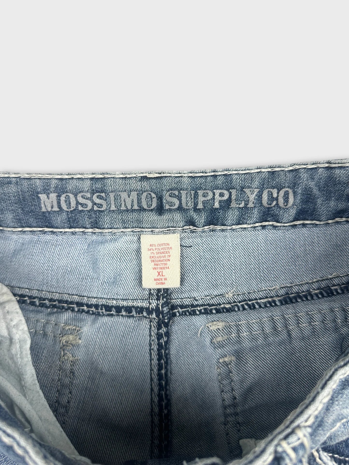 Detail view of denim shorts showing light blue color and brand tag.