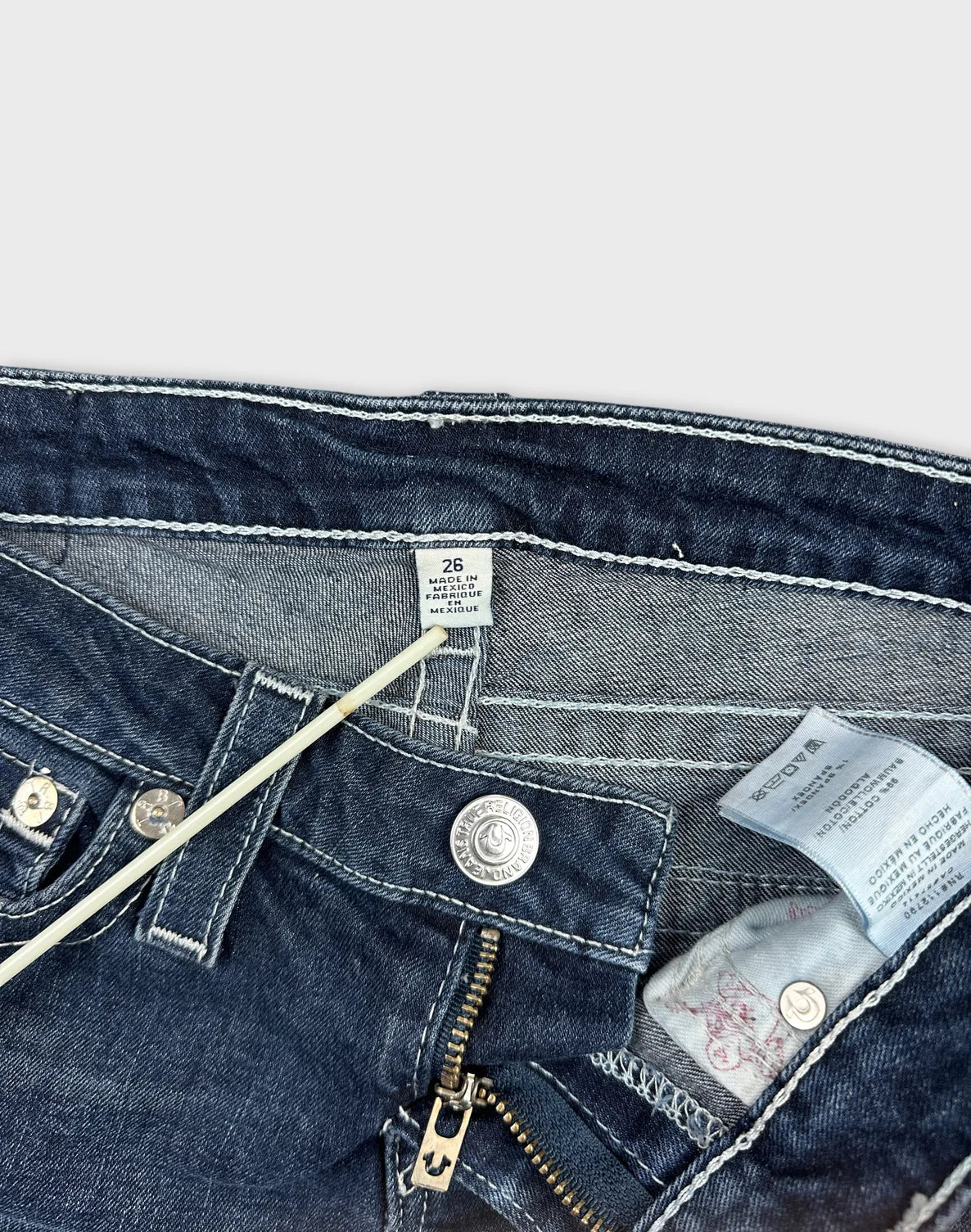 Detail view of women's denim shorts featuring dark blue color and zipper.