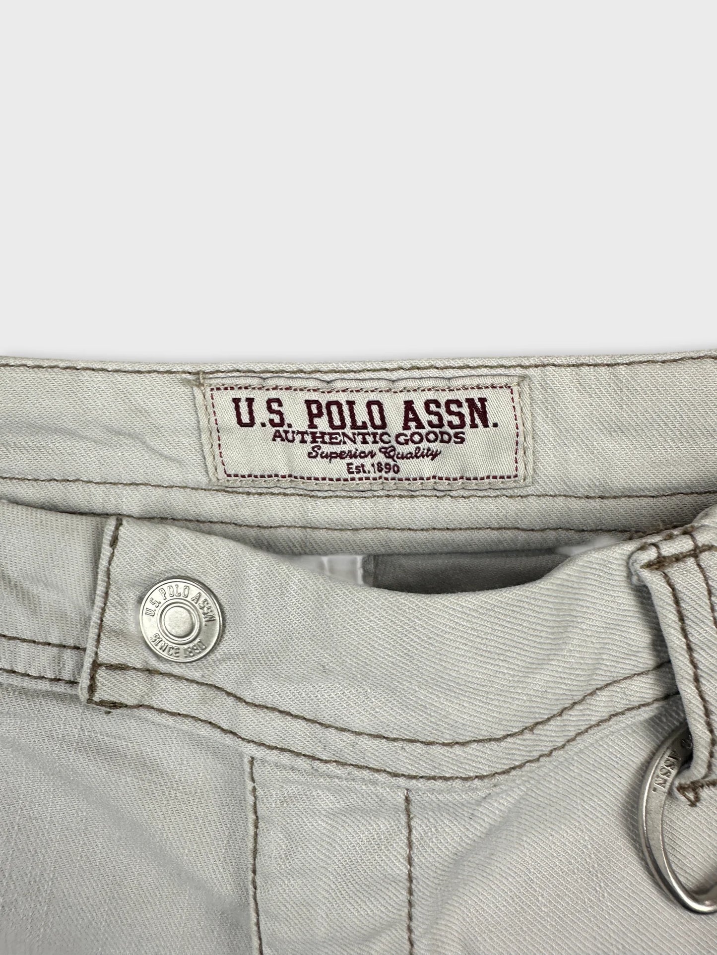 Detail view of women's denim shorts in light color with branded label.