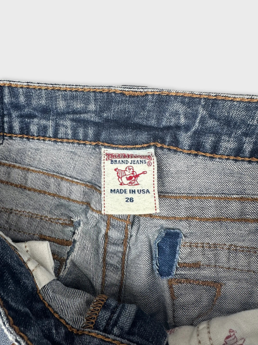 Detail view of women denim shorts in blue featuring a brand tag.