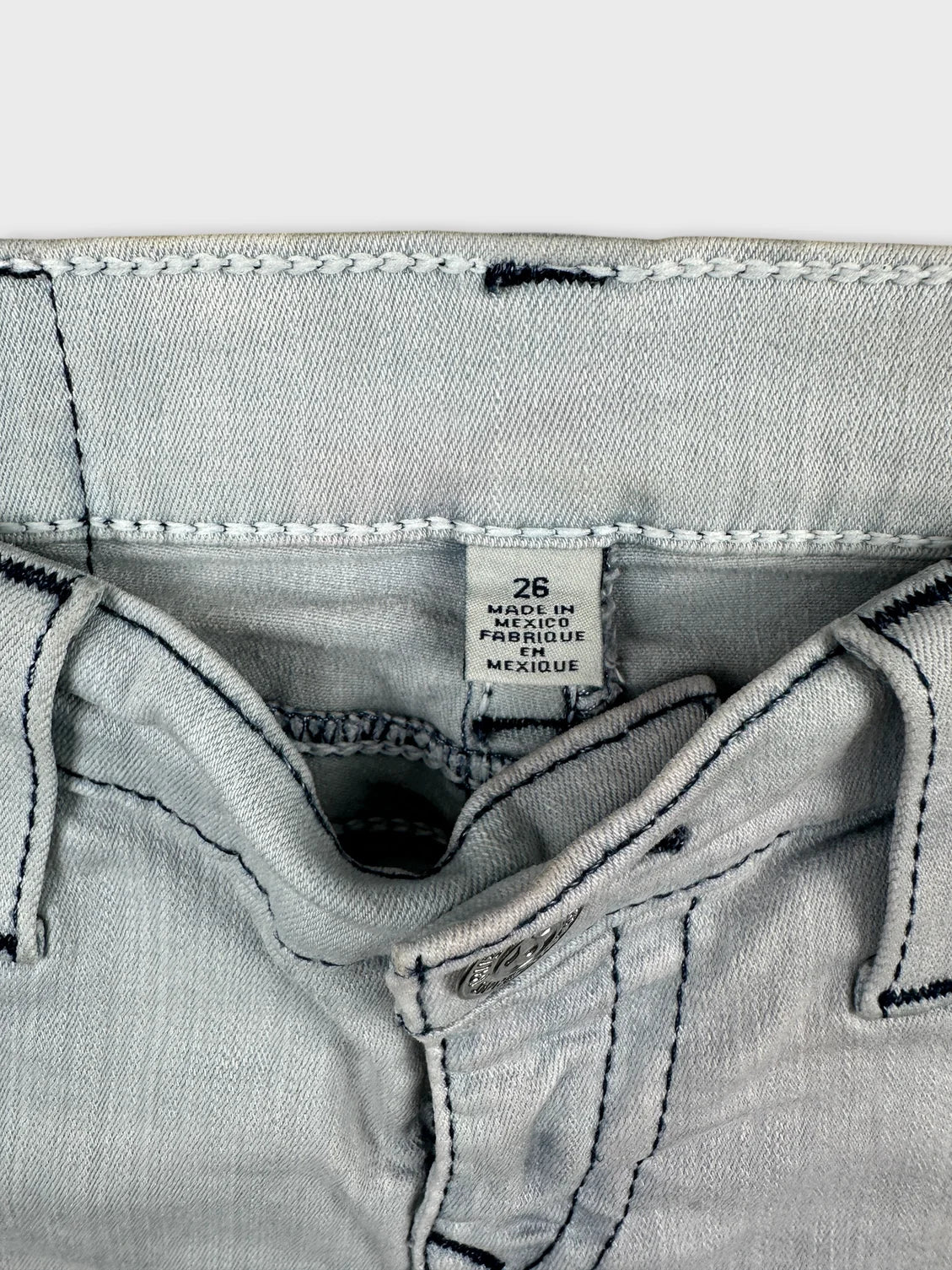 Detail view of women denim shorts in light gray with contrasting stitching.