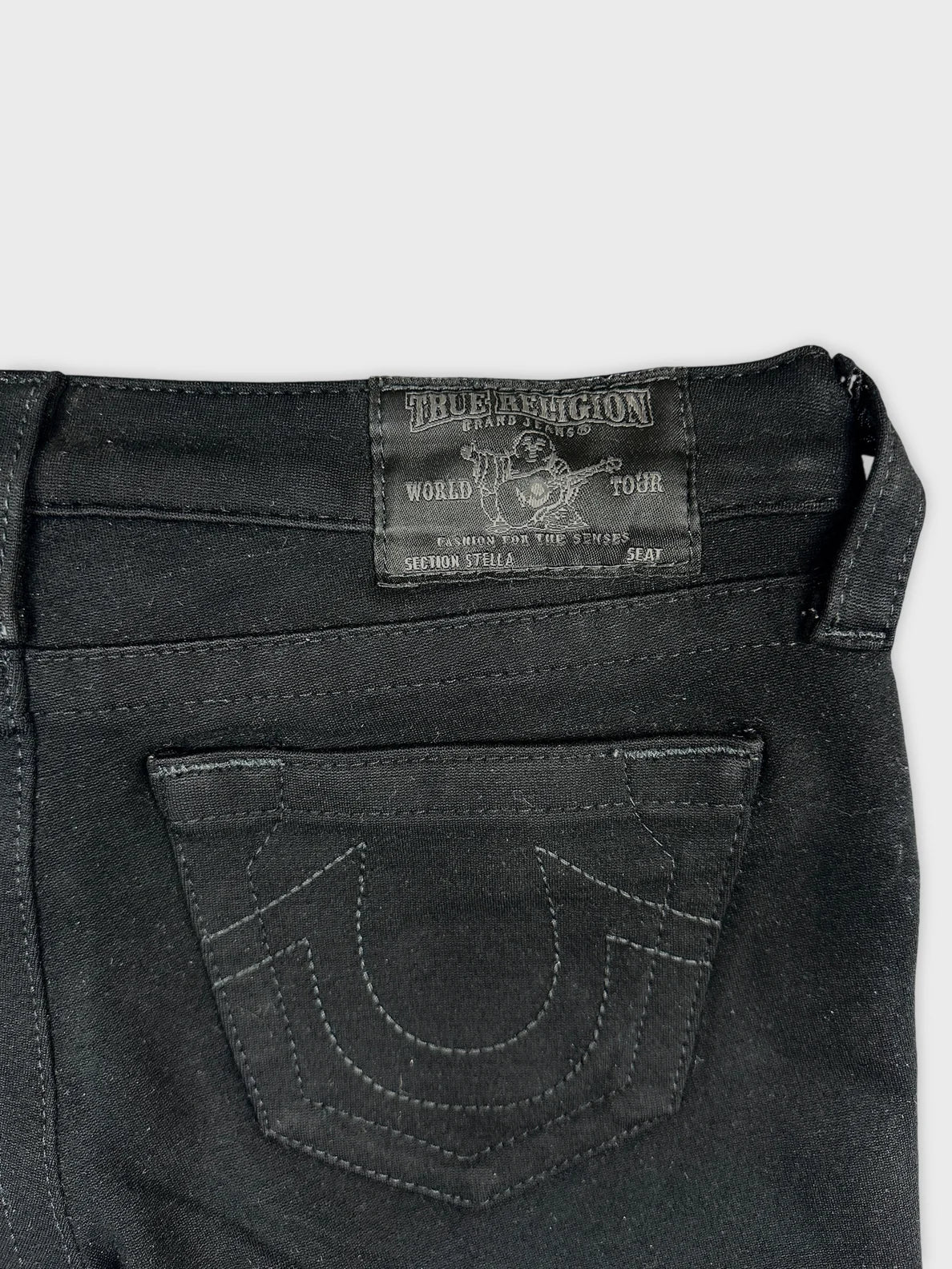 Detail view of black denim shorts showcasing the back pocket design.