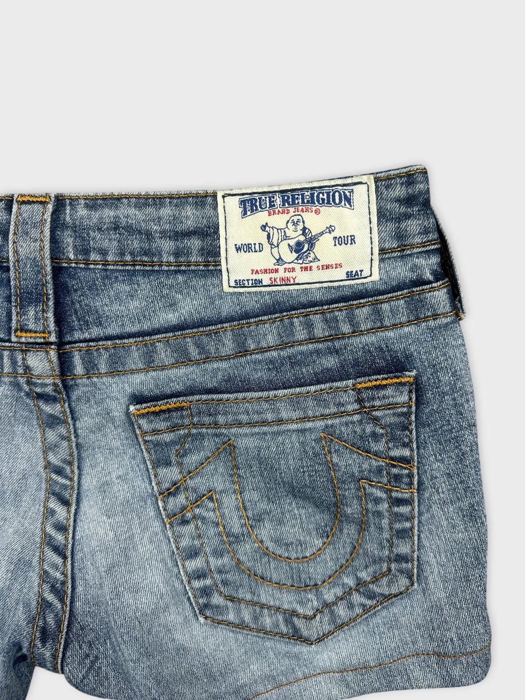Detail view of women's denim shorts in light blue with embroidered back pockets.