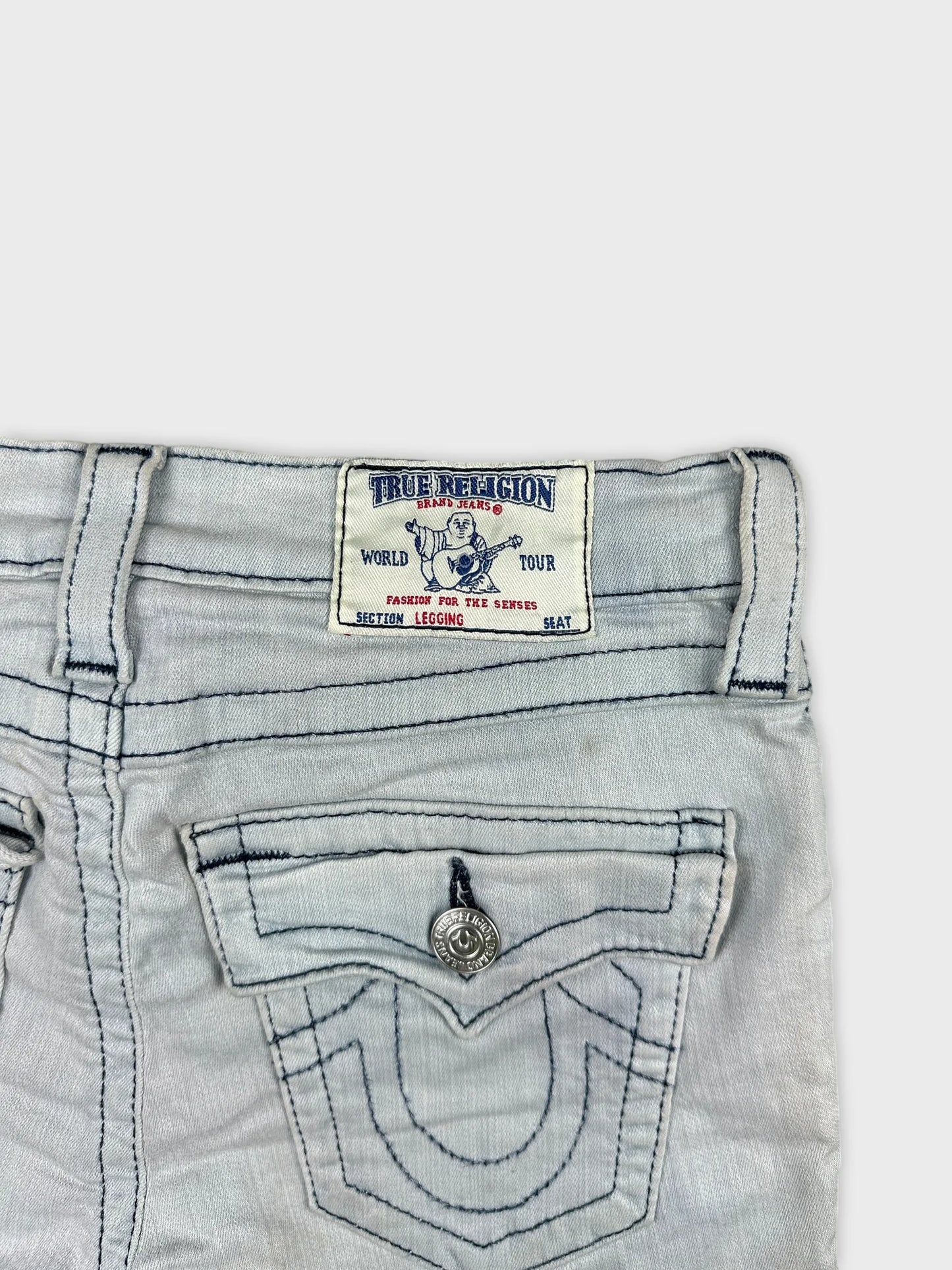 Detail view of women denim shorts in light gray with visible stitching and label.